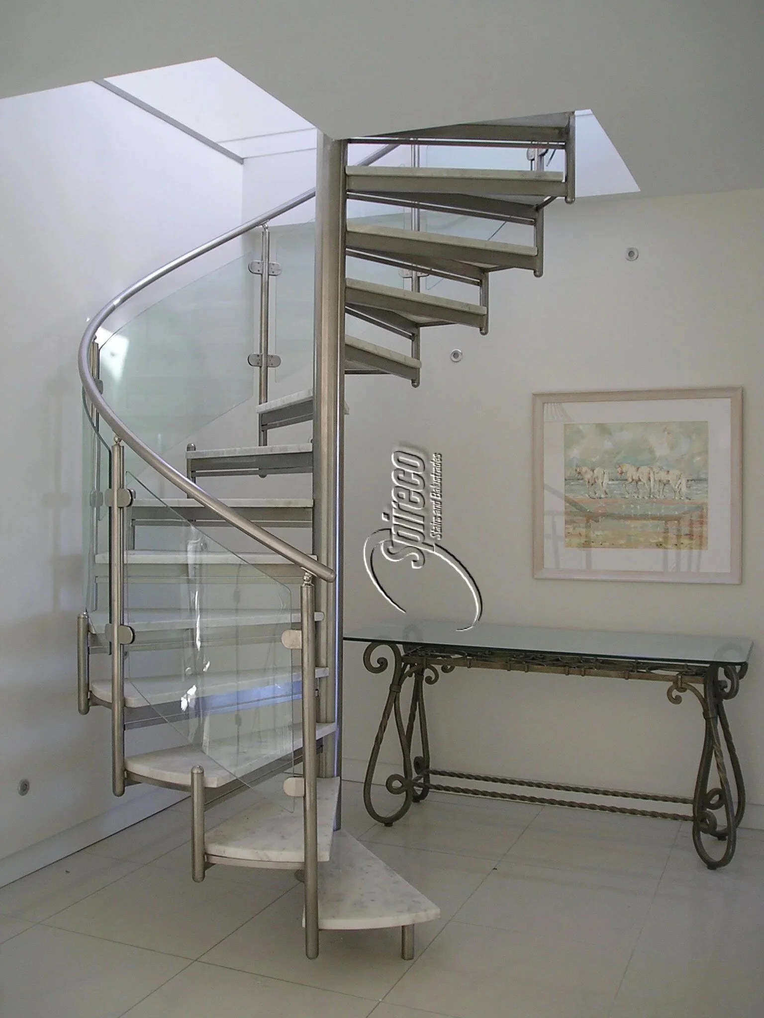 ‘Marble Spectral’ model Spiral Stairs.
Curved Glass Balustrade on Polished Stainless Steel Handrail, Posts & Frame with Marble treads.