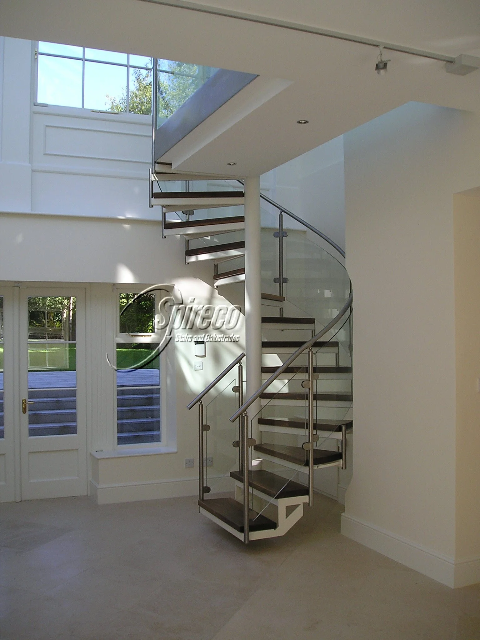 Avoca ‘Orbital’ Spiral Stairs.
Cream ‘Orbital’ Spiral Stairs with Stainless Steel Balusters & Handrail and Curved Glass infill panels with 2″ Walnut Treads.