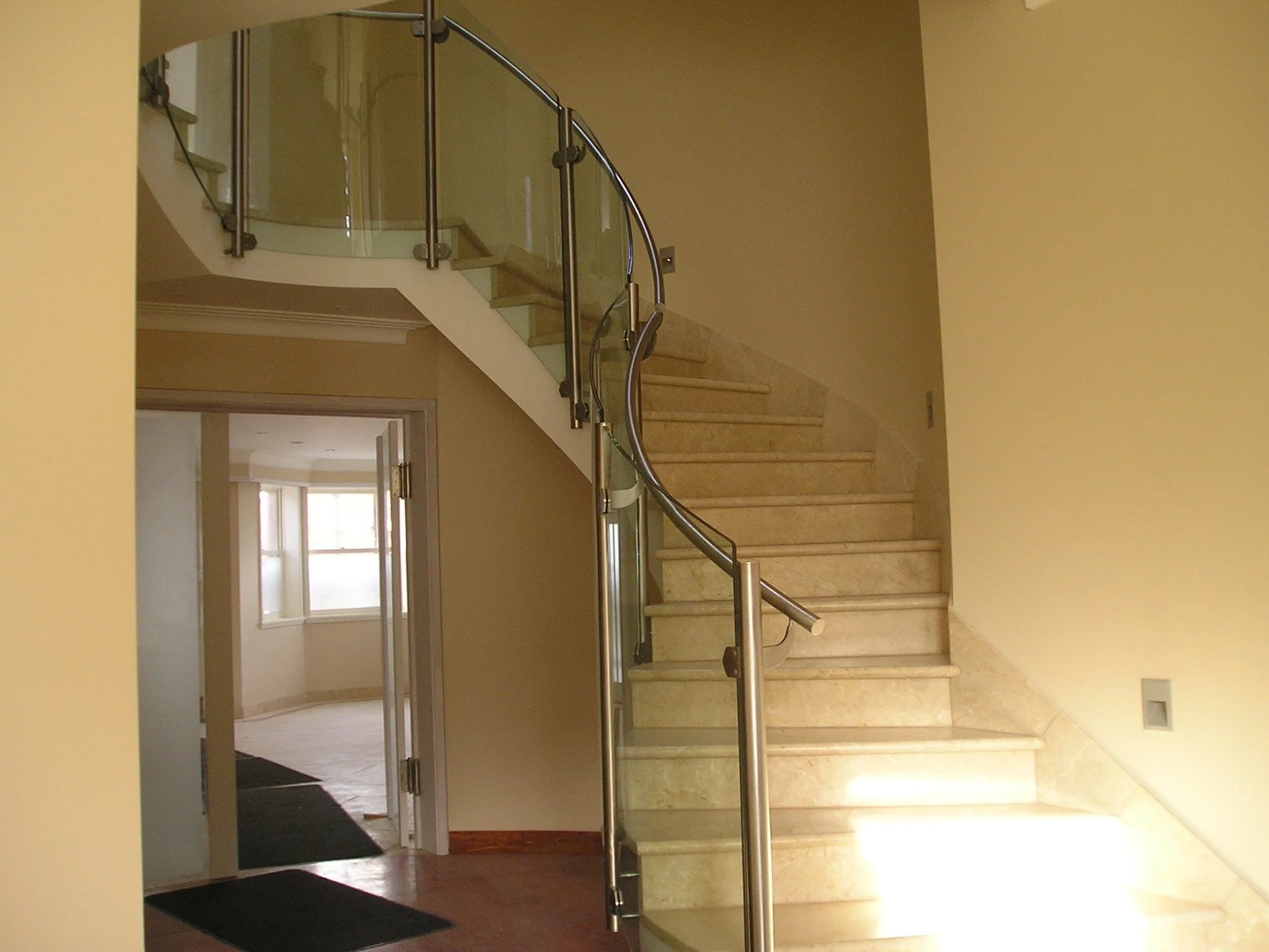 Side-mounted Stainless Steel and Glass Balustrade to curved stairs.