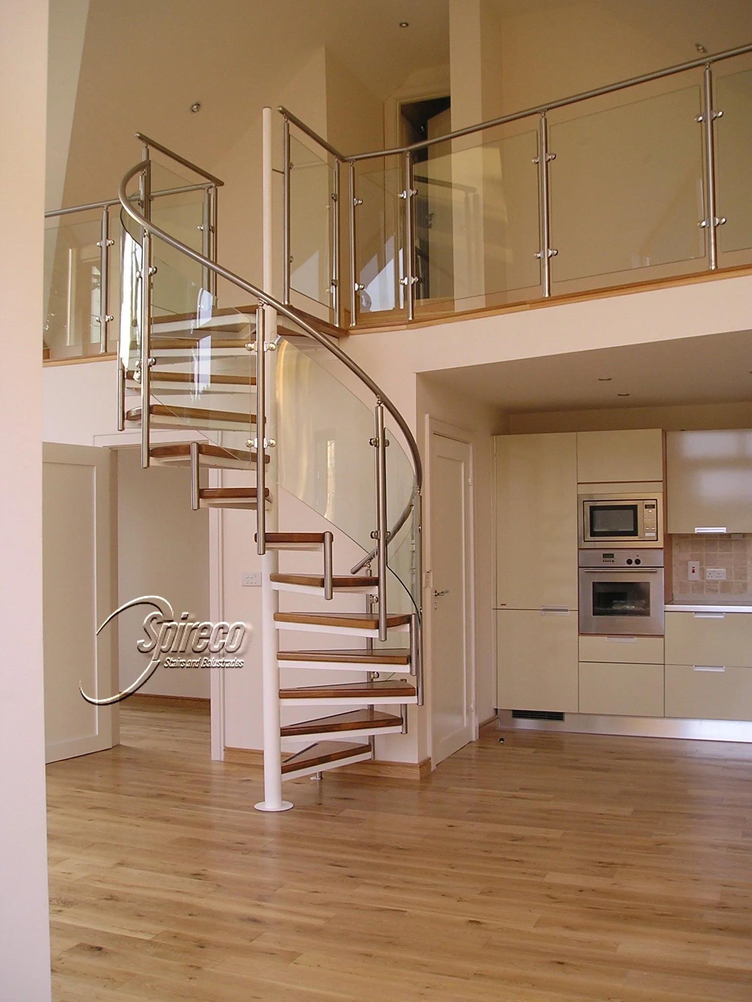 ‘Seafield Orbital’ Spiral Stairs.
Curved Glass Balustrade with Stainless Steel Handrail and Posts with choice of 2″ thick Hardwood Treads.
