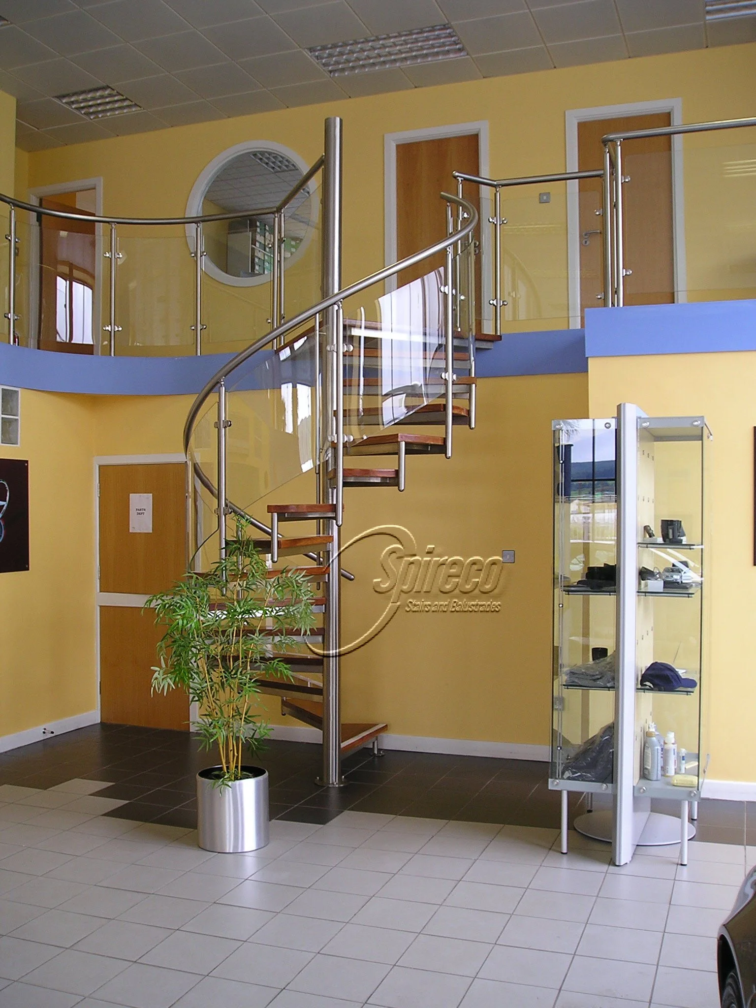 ‘Mercedes Spectral’ Spiral Stairs.
Polished Stainless Steel Framed Spiral Stairs with Curved Glass Balustrade and 2″ American White Oak treads.