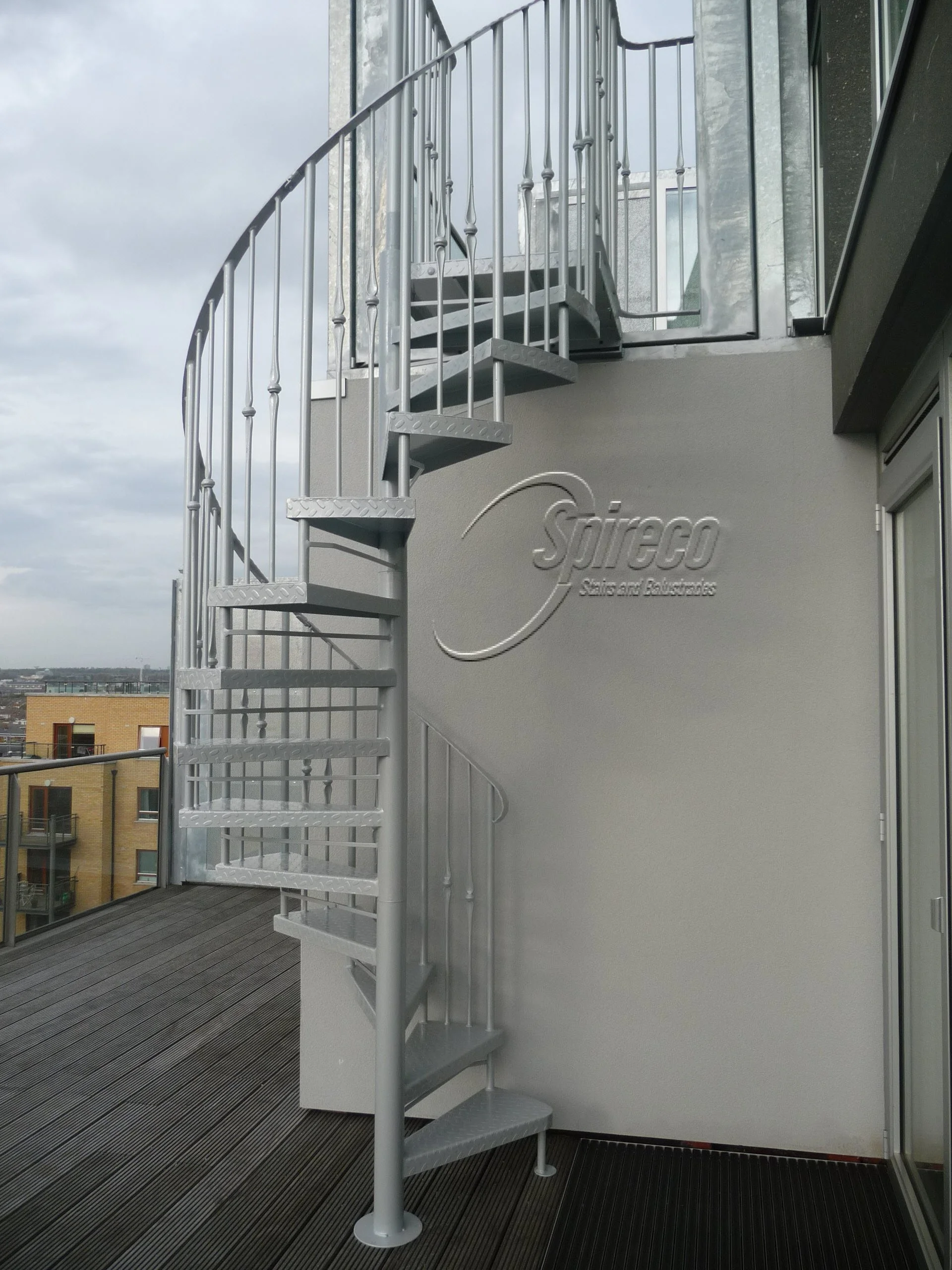 Powder-coated ‘Penthouse’ Spiral.
Penthouse Powder-coated Wrought Iron Spiral Stairs with Folded Chequer Plate Treads and Landing with Flat Metal Handrail.