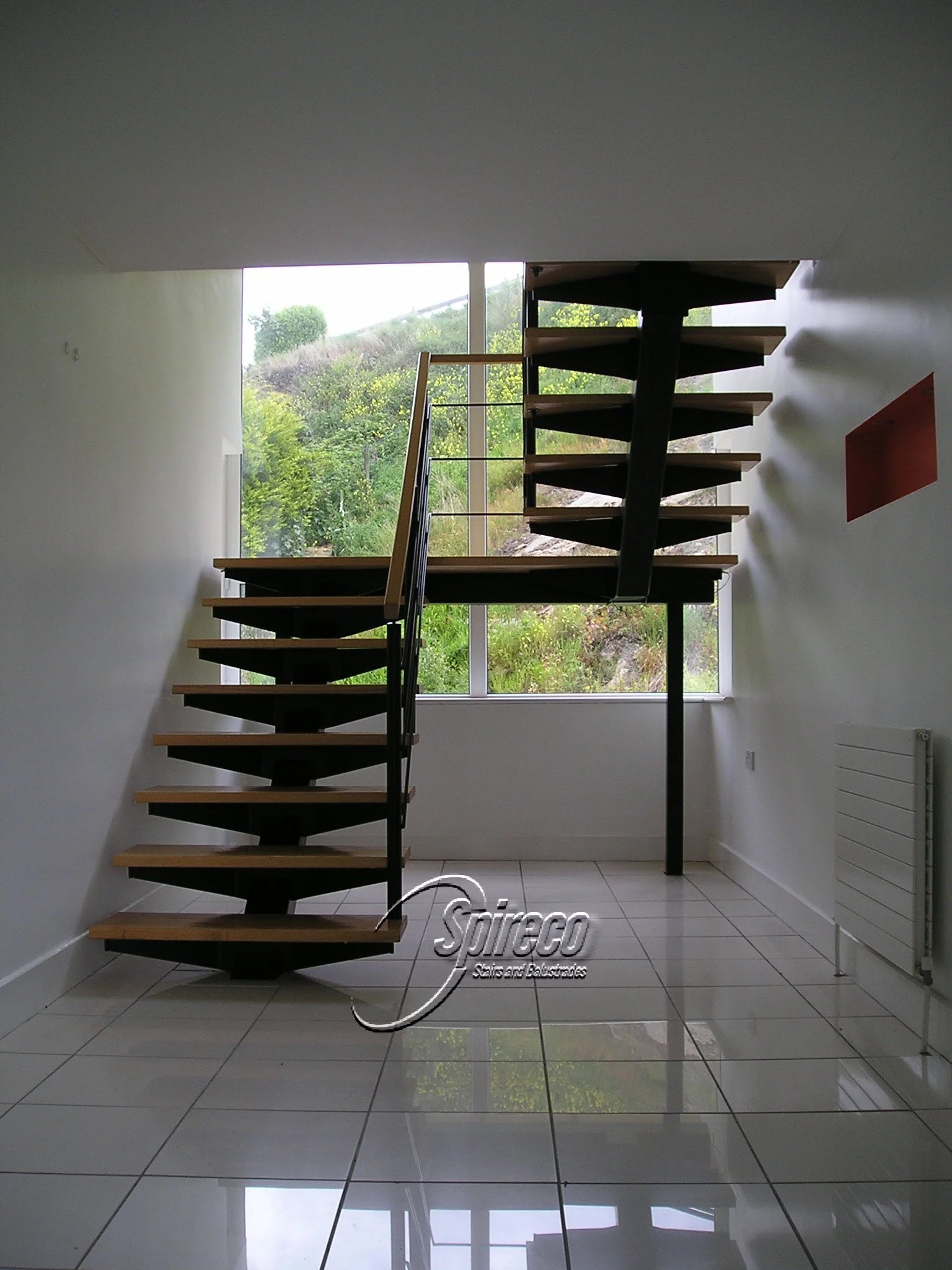 ‘Redrock’ Bat-Wing Stairs. Black ‘Bat-Wing’ stairs with Maple treads and Handrail with Black Steel Rod Balustrading.