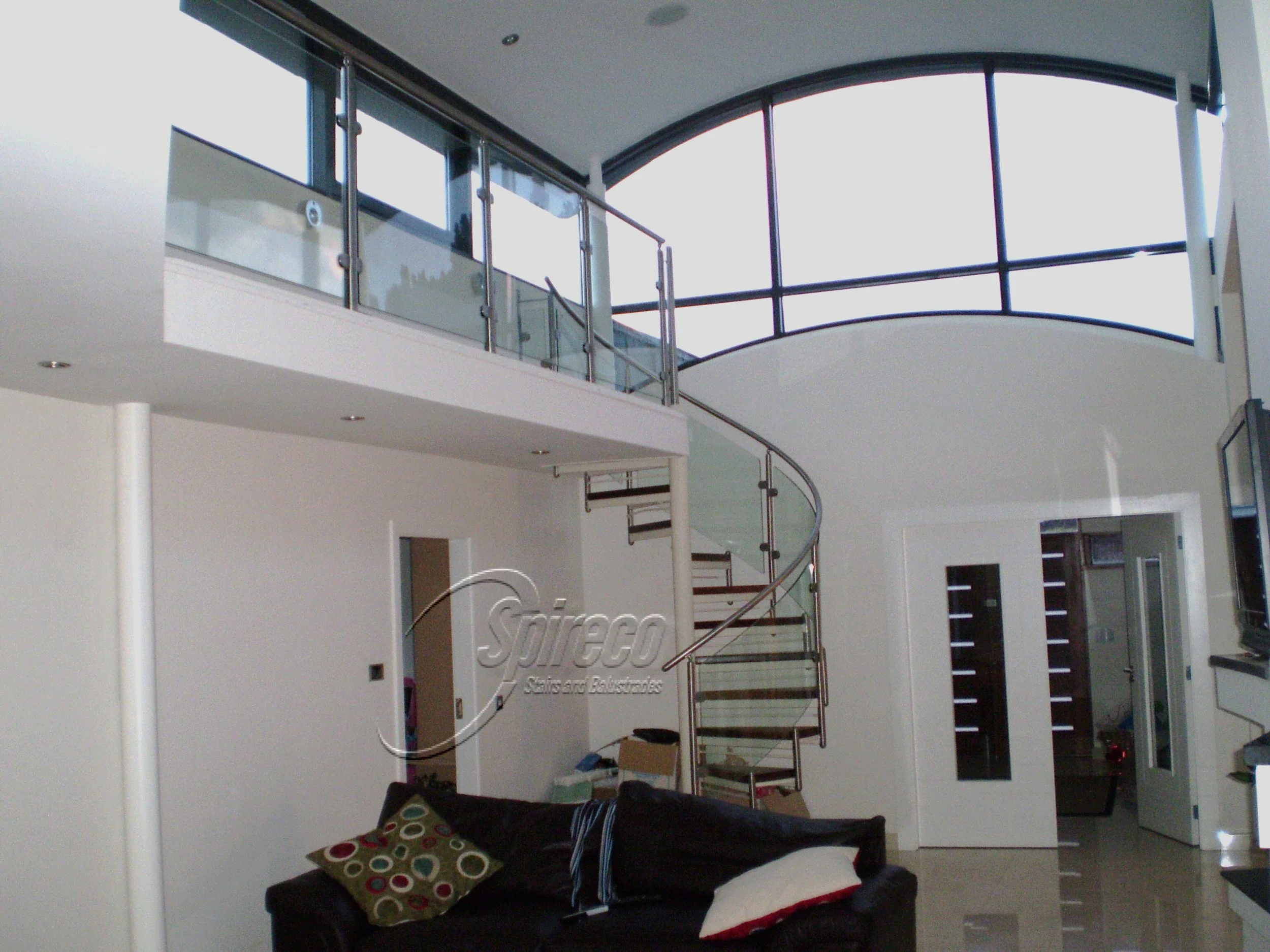 ‘Monkstown’ Orbital.
Orbital ‘ style Spiral Stairs with Curved Glass Balustrade, Stainless Steel Handrail & 2″ thick Walnut Treads.