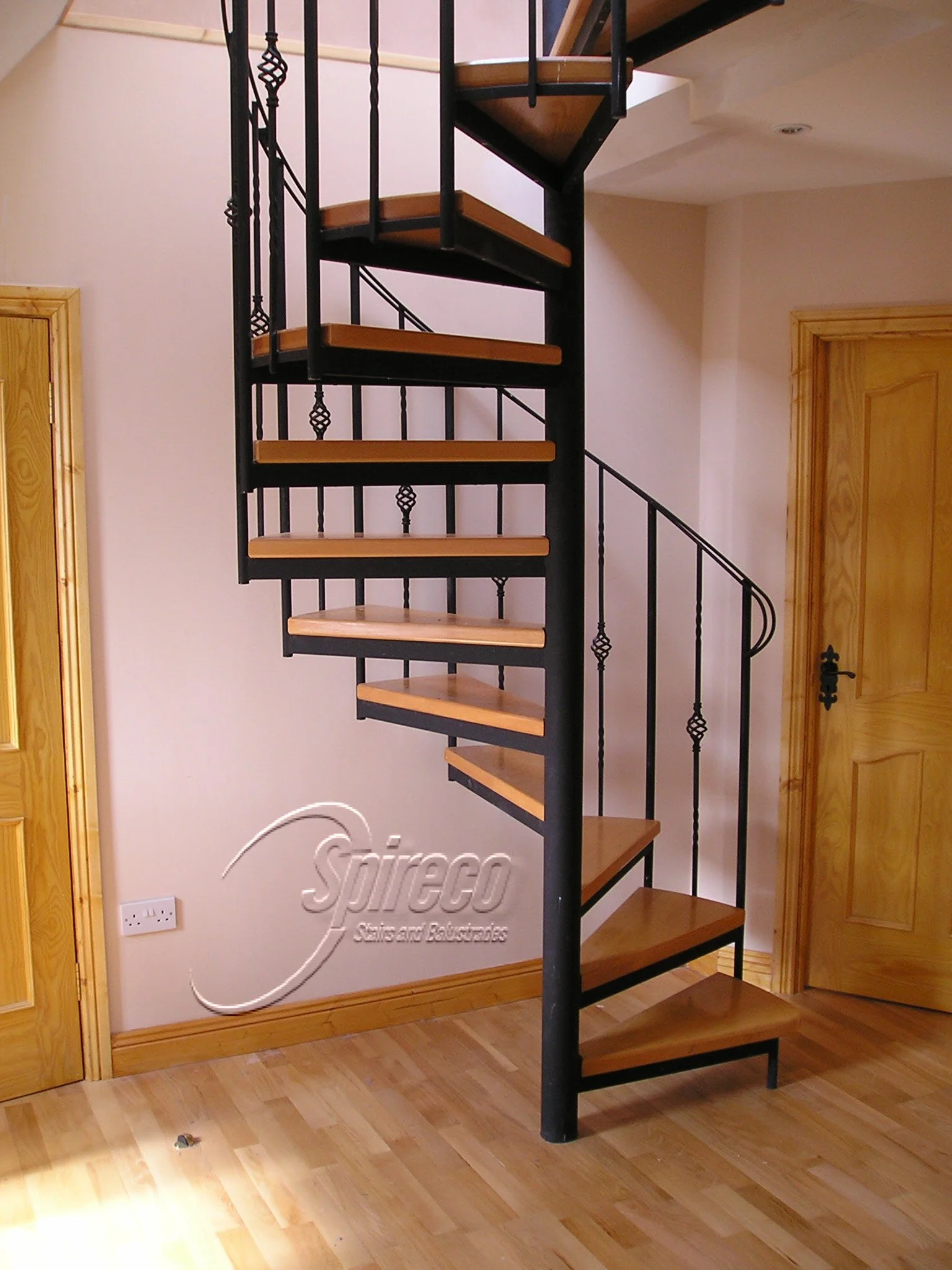 ‘Traditional’ style Spiral Stairs.
‘Traditional’ style Wrought Iron Spiral Stairs with Basket Balustrade infill & 2″ Beech Treads.