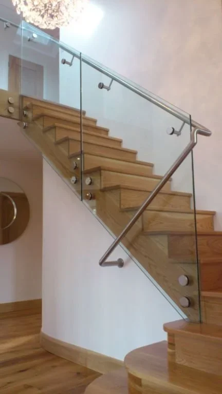 Cantilver Glass Balustrade on Oak Stairs. Cantilver Glass Balustrade connected to Solid Oak Stairs via Stainless Steel Disc Connectors with Stainless Steel Handrail connected through Glass Balustrade.