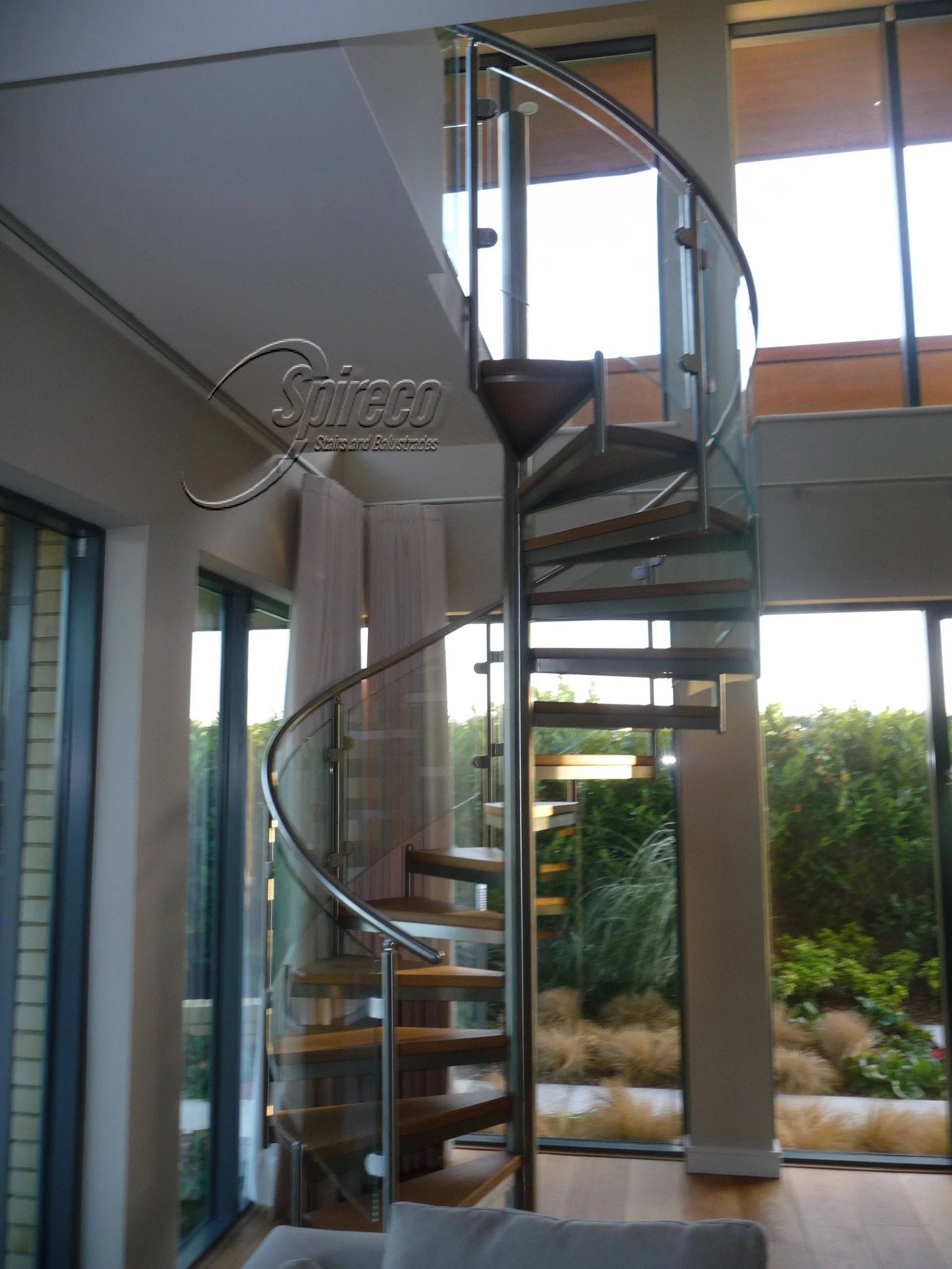 ‘Myra Spectral’ Spiral Stairs.
‘Spectral’ Fully Stainless Steel Steel Spiral Stairs with Curved Glass Balustrade & 2″ thick Oak treads.