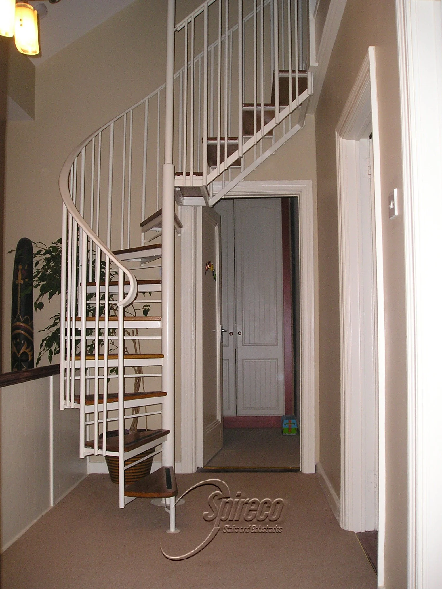 ‘Executive Hip’ Style Spiral Stairs.
Combined Spiral & Straight flight ‘Executive’ style balustrade with Mahogany treads maximises headroom where roof is hipped.