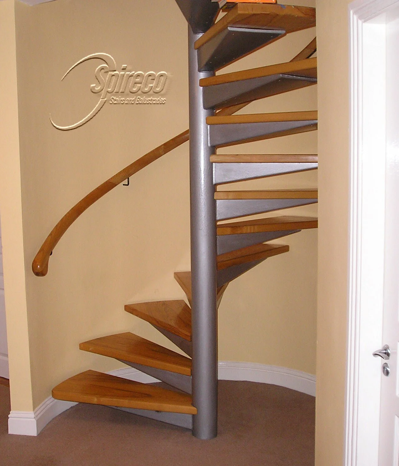 ‘Red Alder’ Handrail & ‘Silver Turret’ Spiral.
Curved Wall Mounted Timber Handrail and Steel framed Spiral Stairs with tapered tray supports for choice of 2″ Hardwood Treads.
