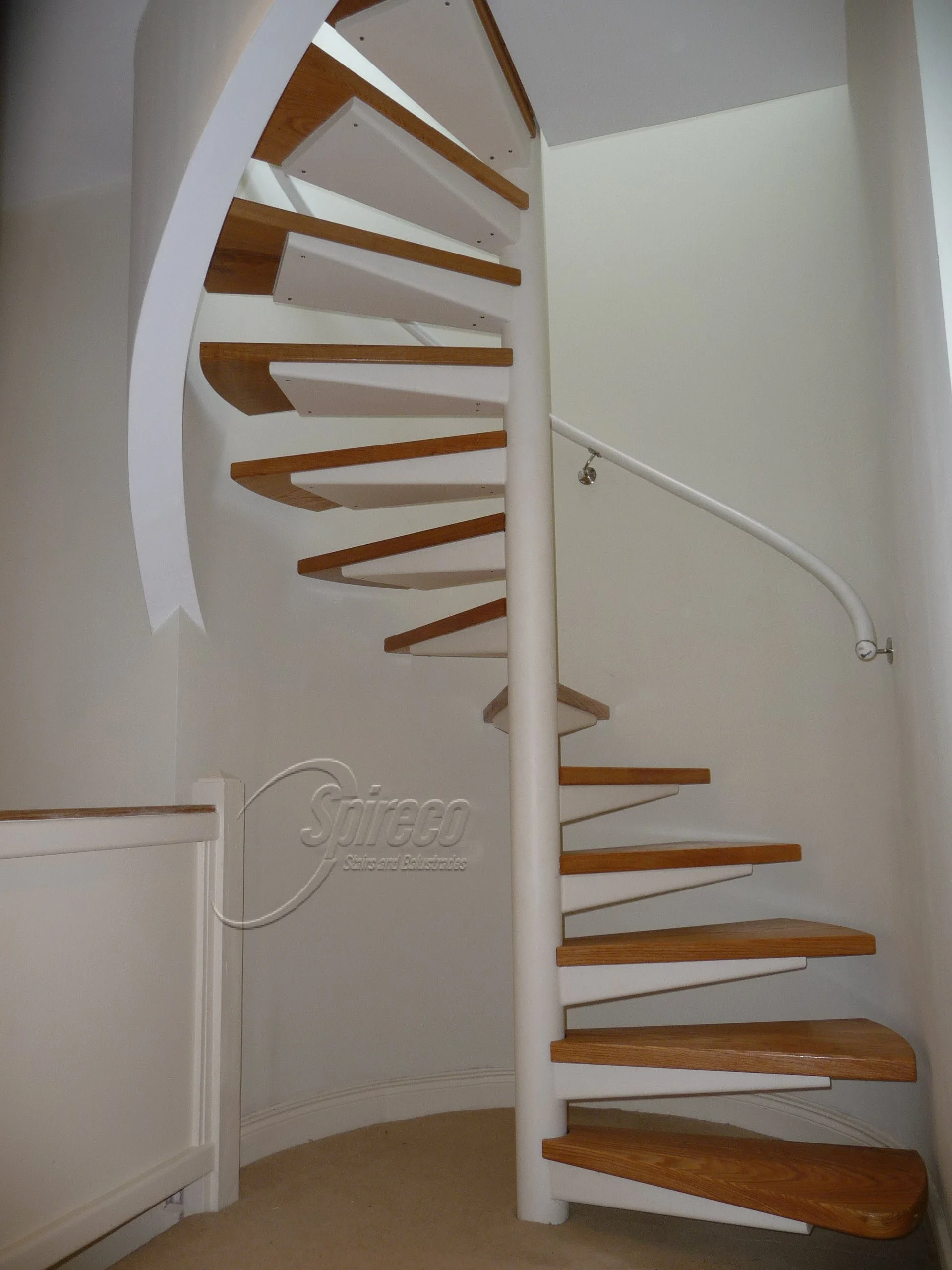 ‘White Turret’ Spiral Stairs.
Curved Wall-mounted Tubular Steel Handrail and Steel framed ‘Turret’ style Spiral Stairs with Tapered Trays Supporting 2″ Oak Treads.