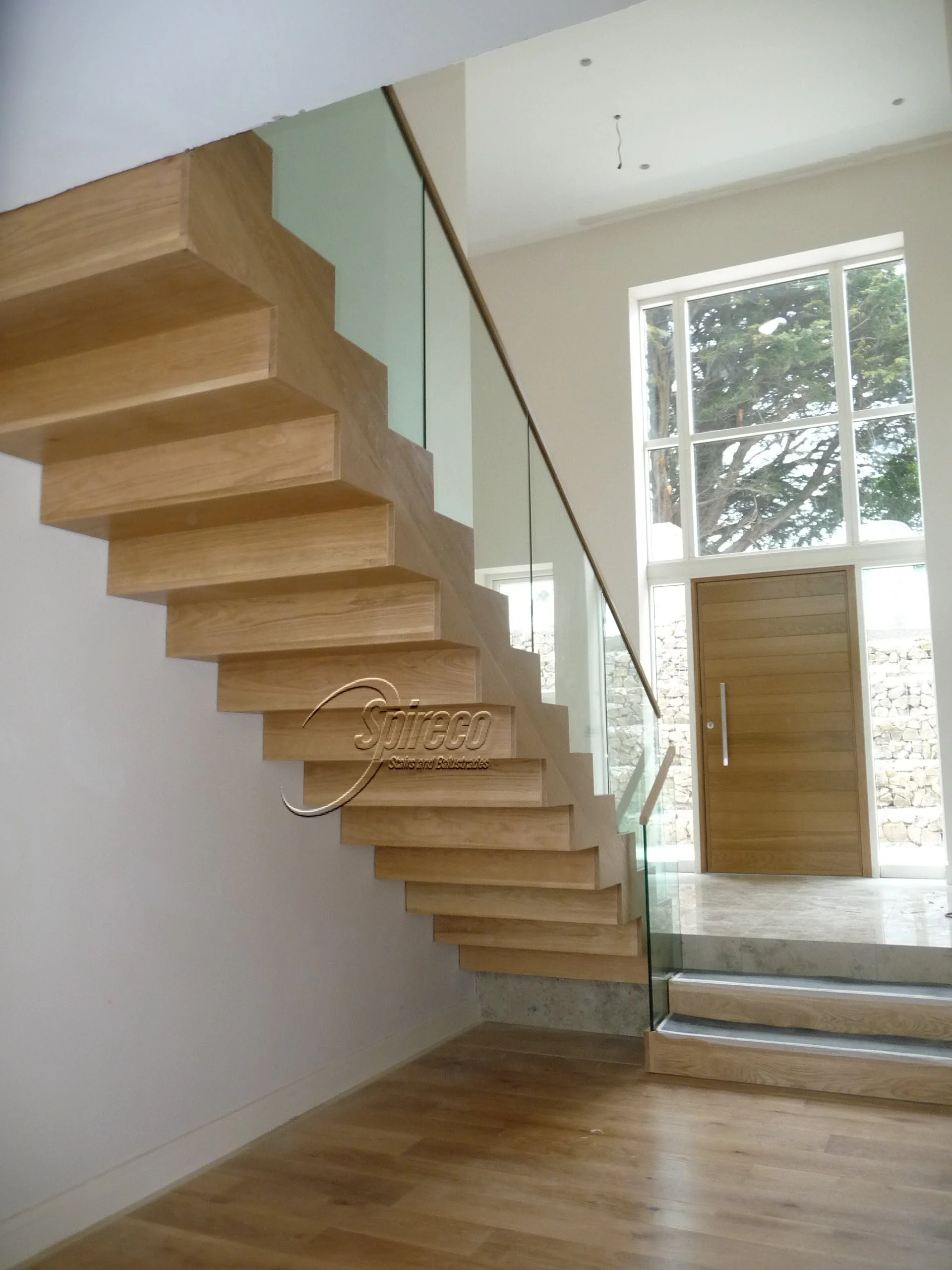 ‘Delgany Oak’ Stairs. Steel framed Stairs Clad in American White Oak with Cantilver Glass Balustrade and Slotted Oak Handrail.