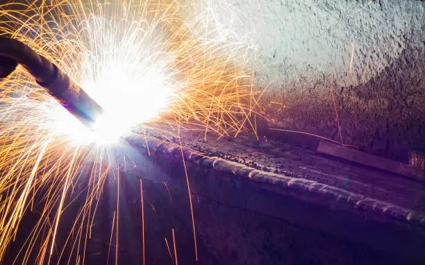 Welding process with bright sparks flying from a metal joint.