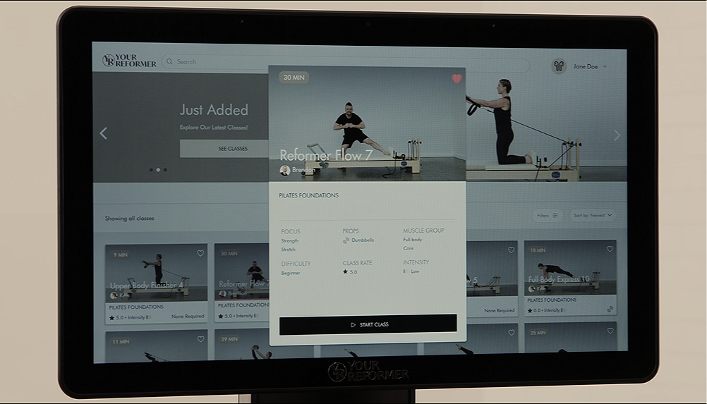 Digital on-demand reformer Pilates platform displayed on a screen with various classes. Featuring instructor images and class details.