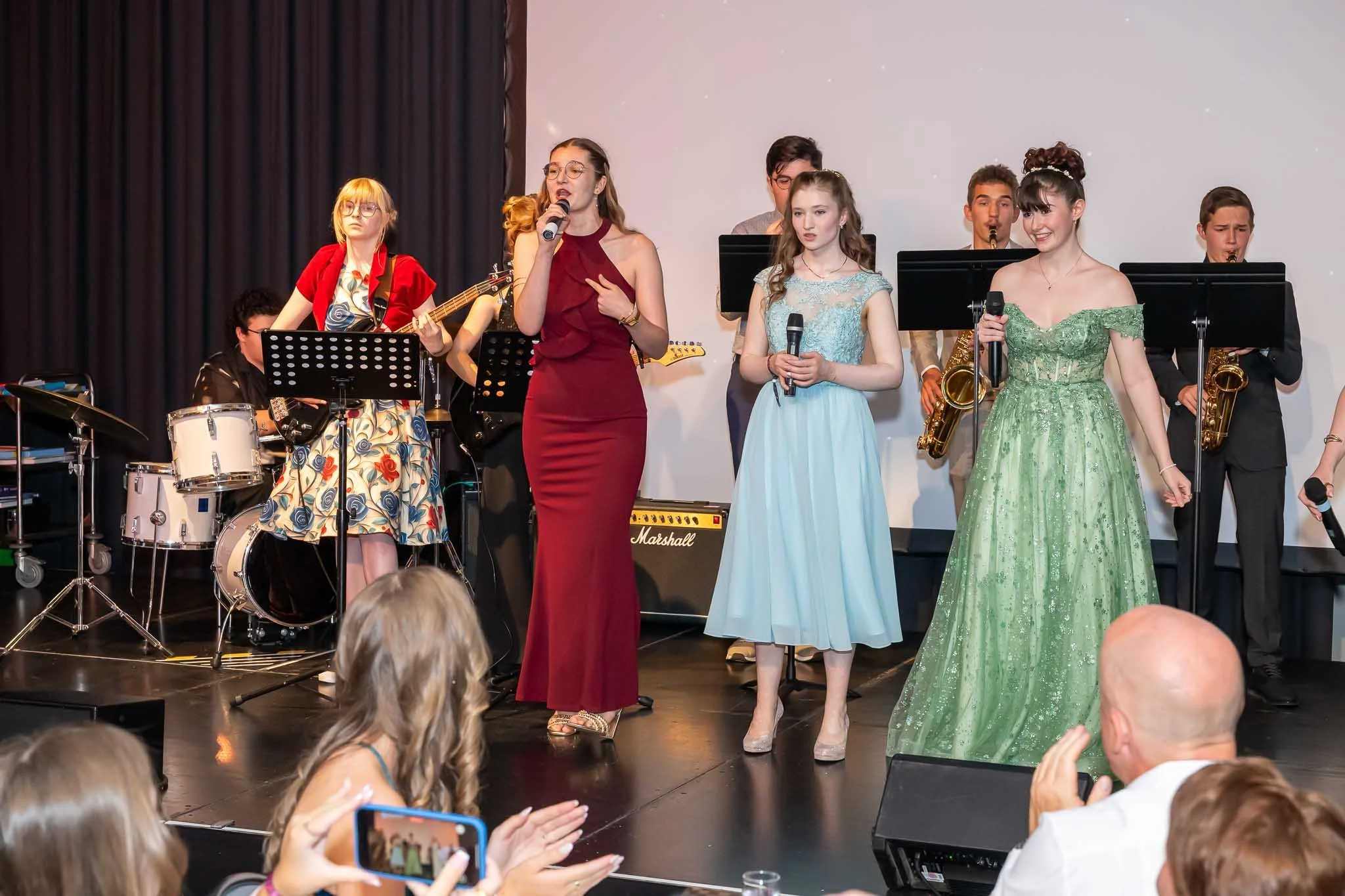 Eine Gruppe von Menschen auf der Bühne mit einer Band beim Abiball