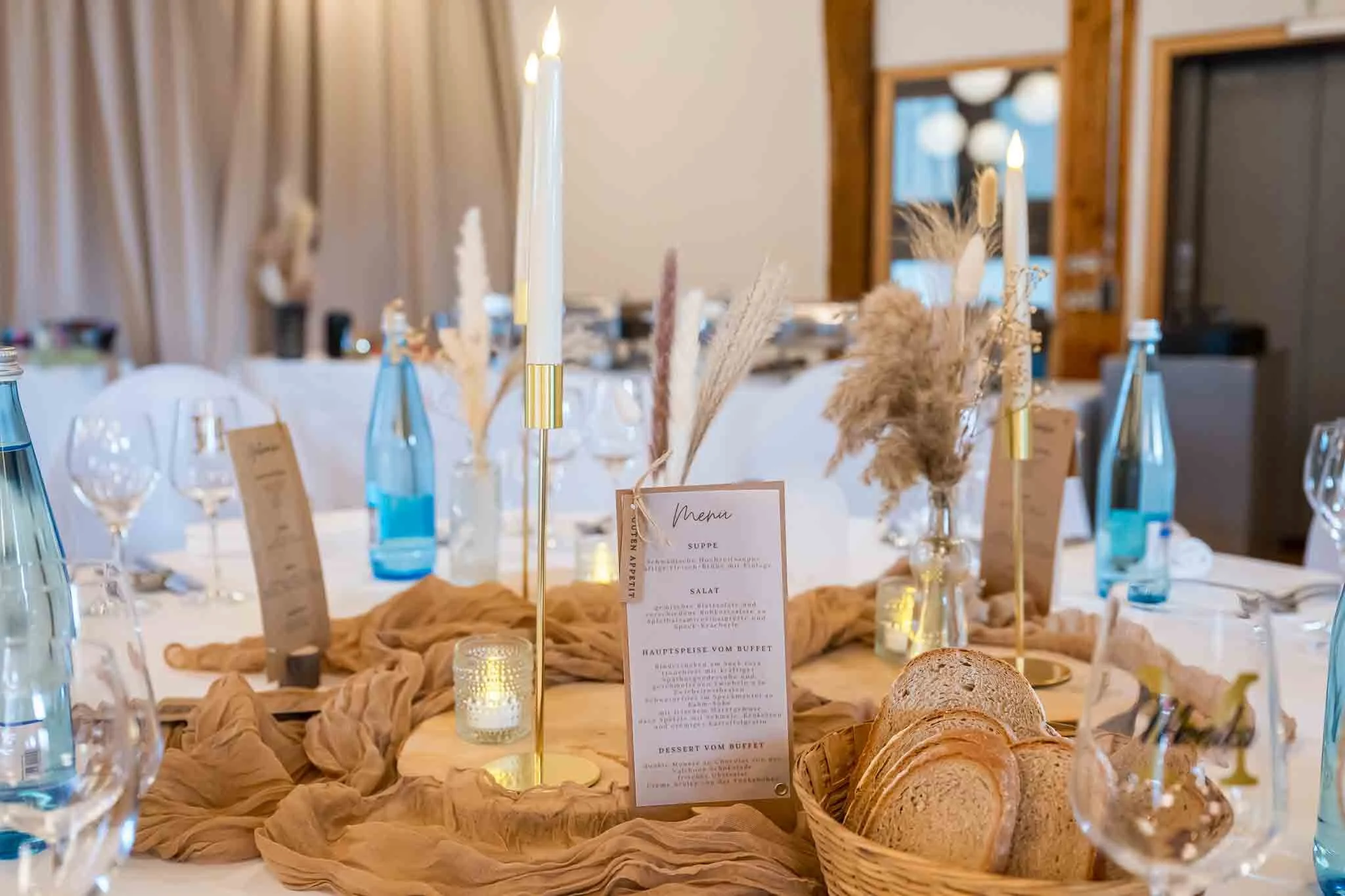 Gedeckter und festlich dekorierter Festtisch mit gold-brauner Dekoration