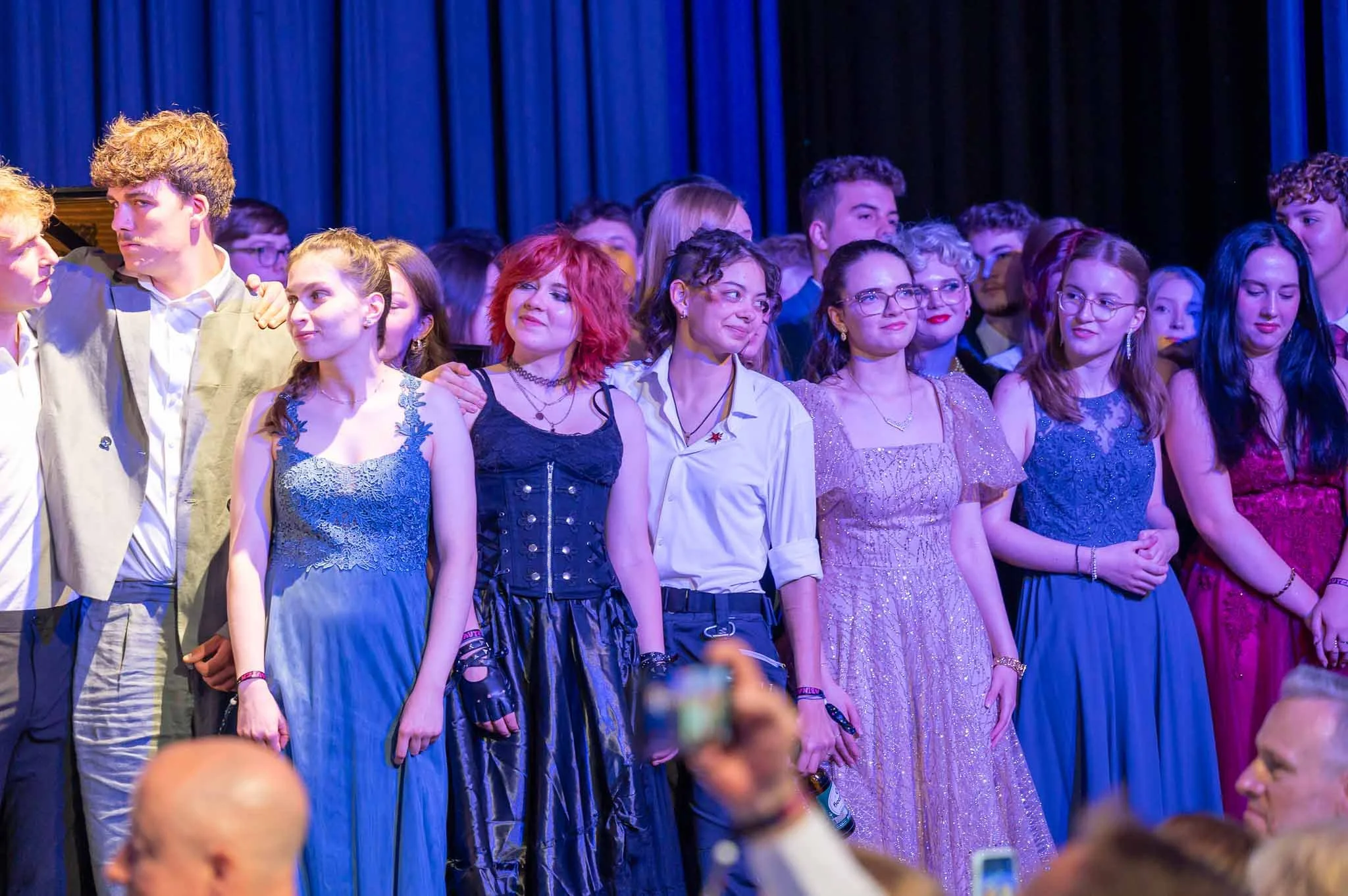 Eine Gruppe von Menschen steht zusammen auf der Bühne beim Abiball