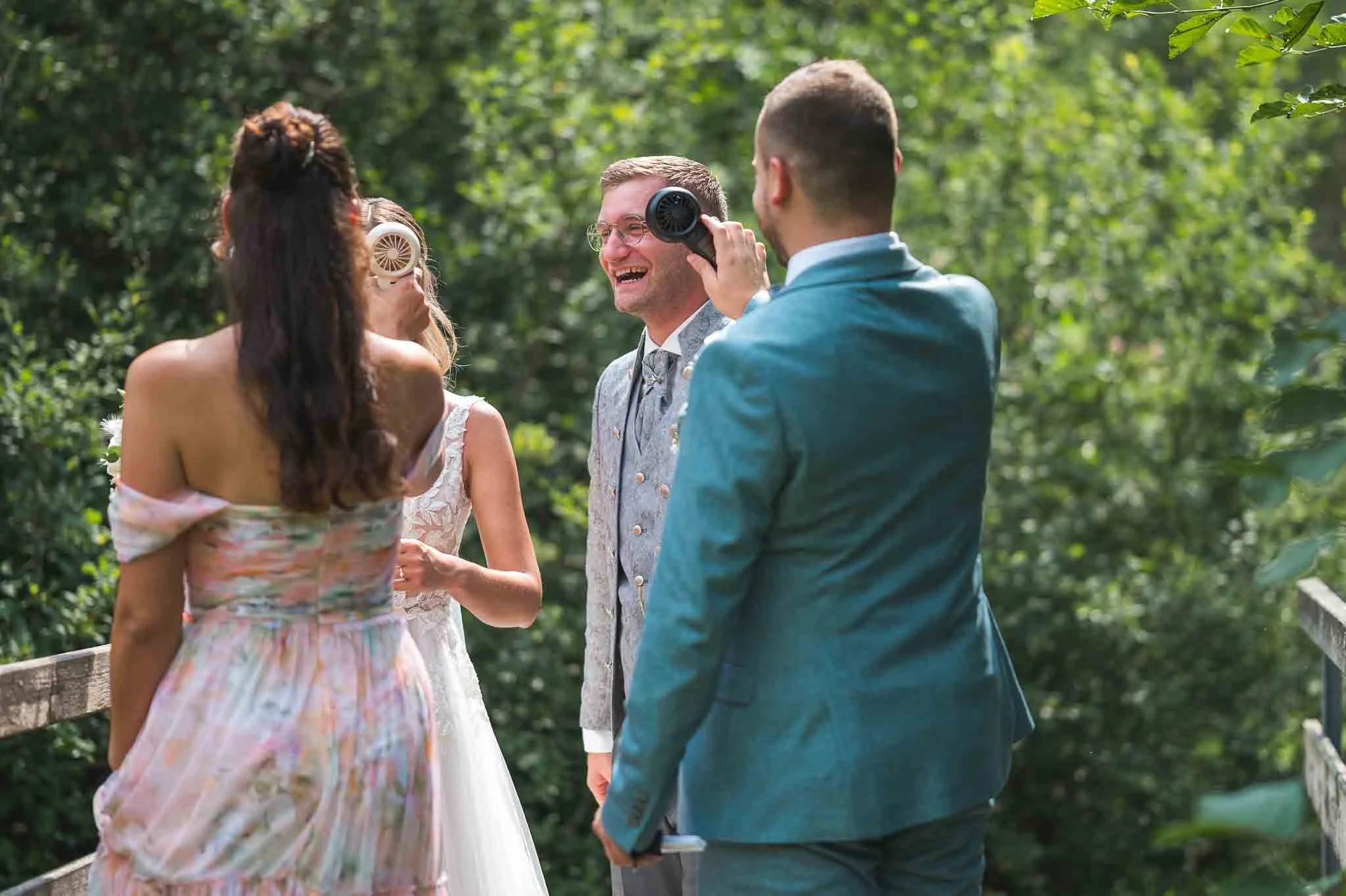 Bild von 4 Personen, die an einem Sommertag in einem Park stehen und lachen