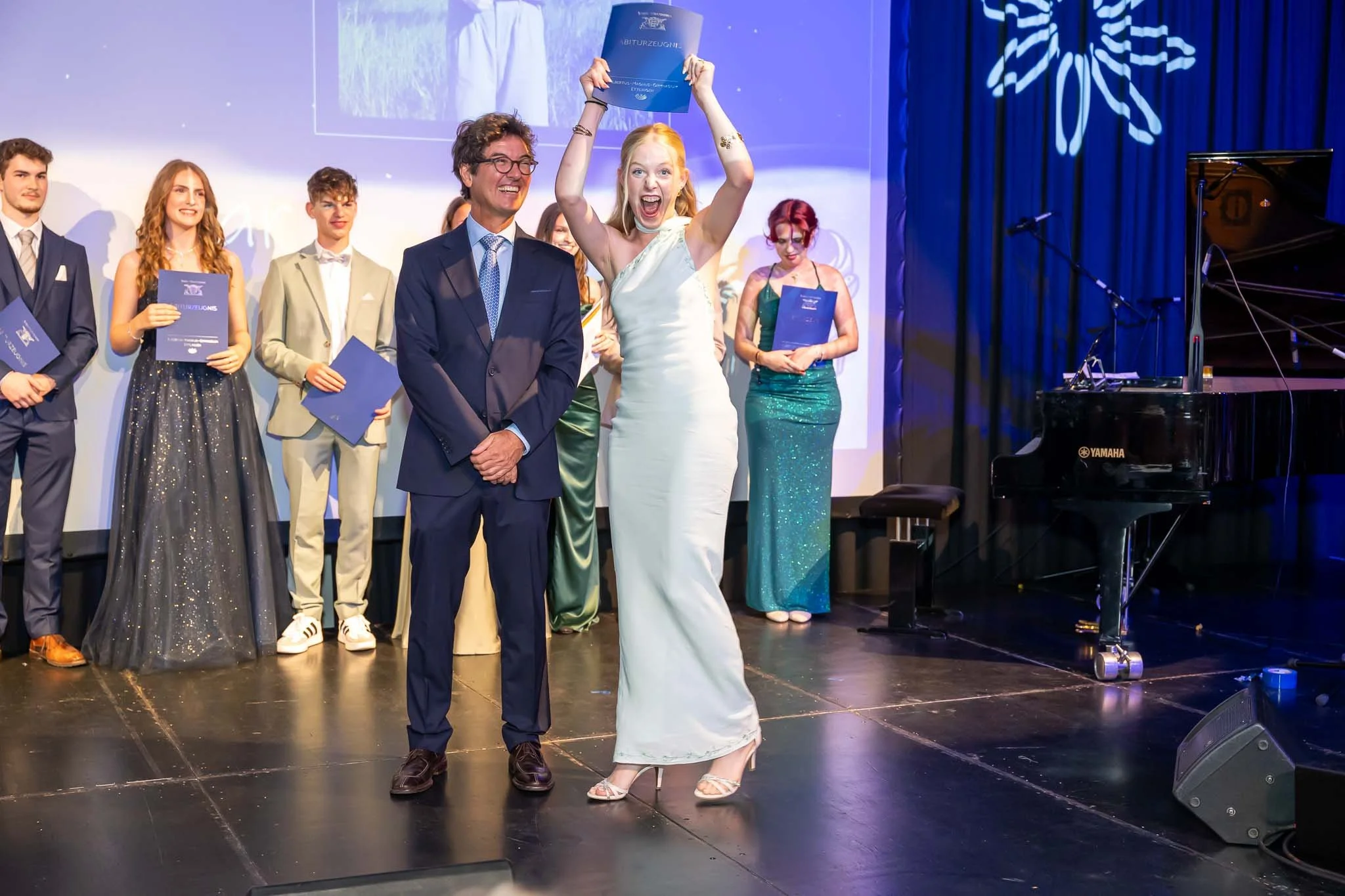 Jubelnde Abiturientin bei der Zeugnisübergabe auf dem Abiball
