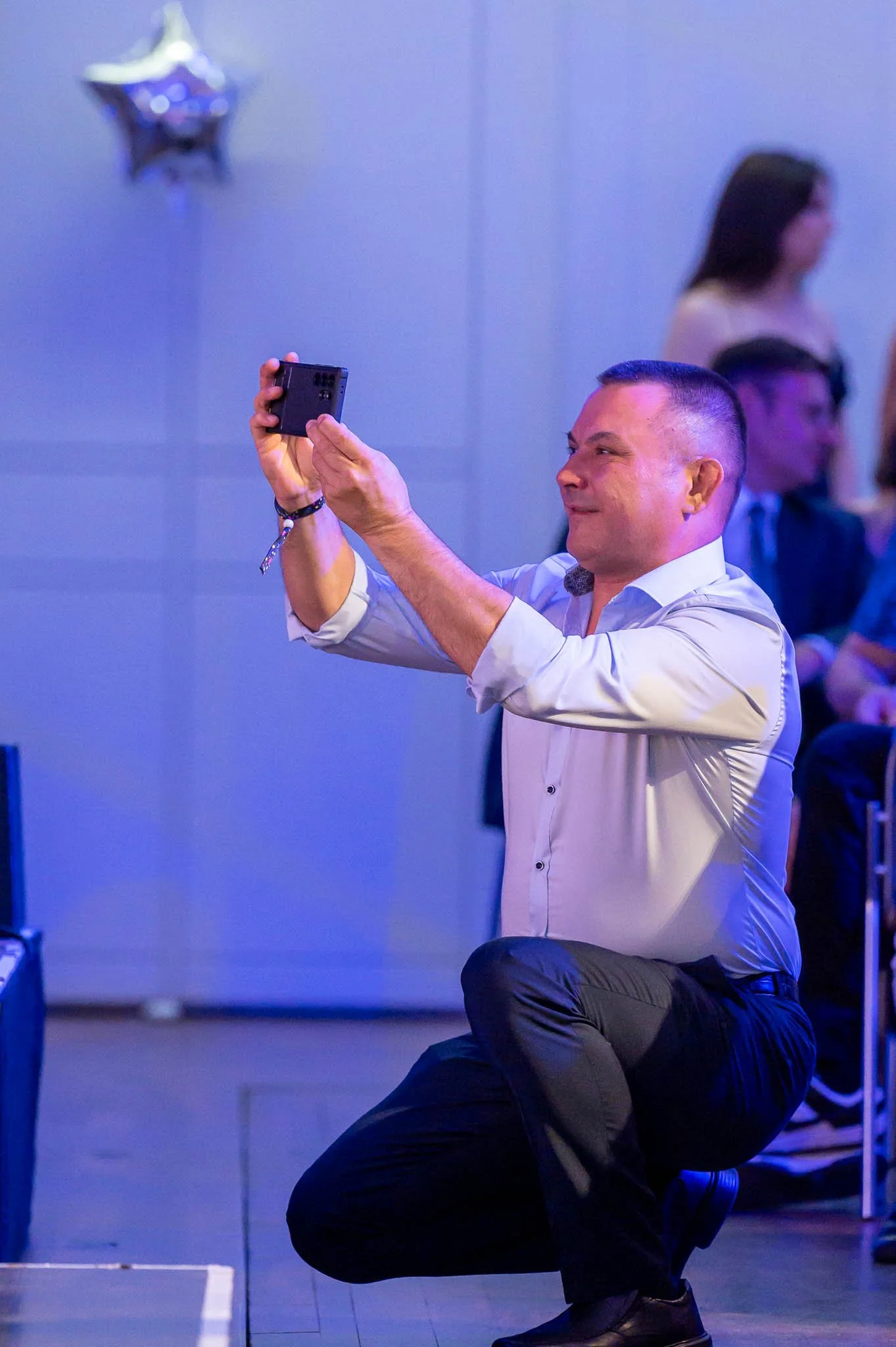 Mann hält eine Kamera und fotografiert eine Frau auf der Abiball-Bühne
