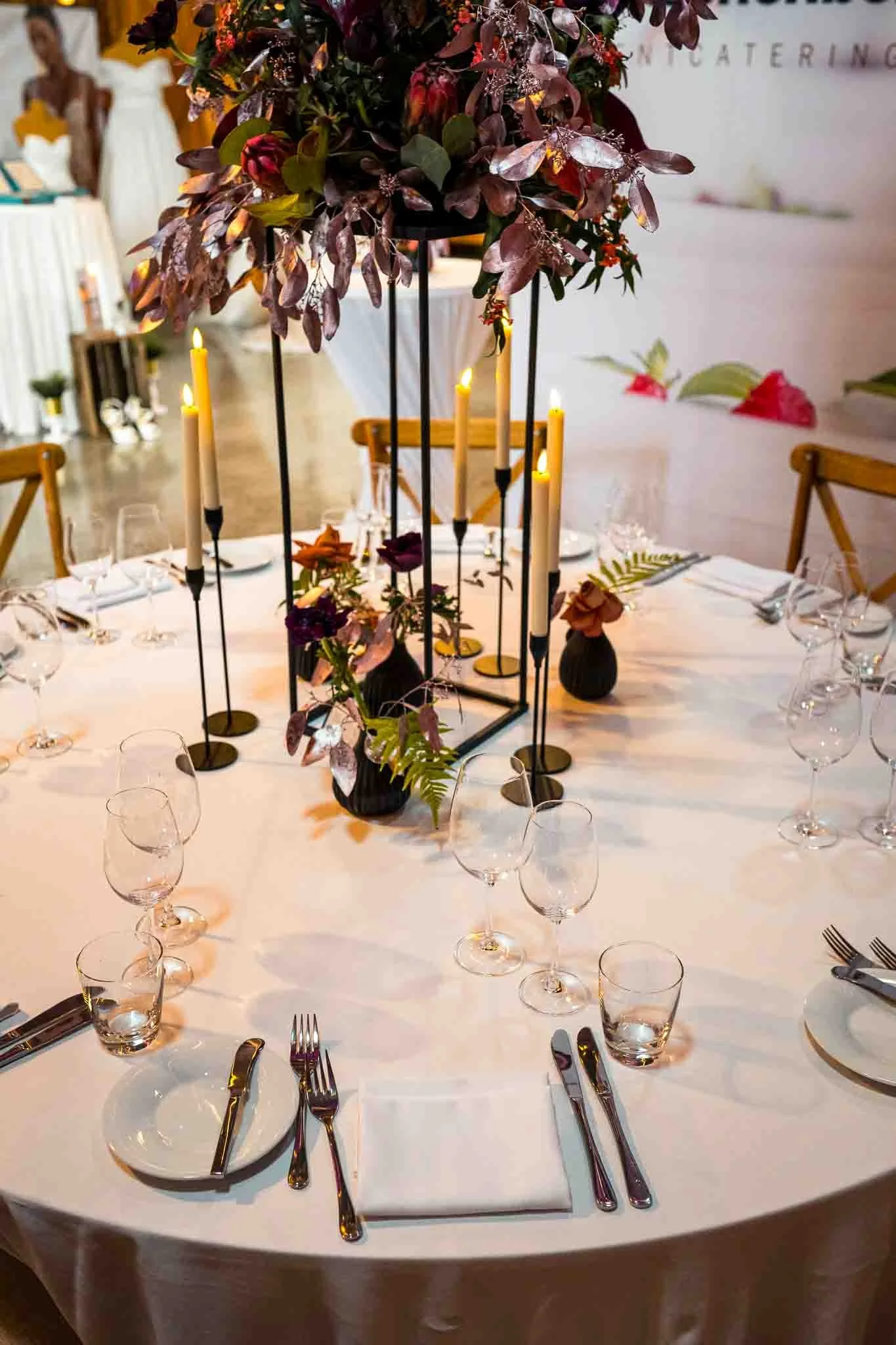 Ein Hochzeitstisch mit einem großem Dekoelement mit Blumen und Kerzen