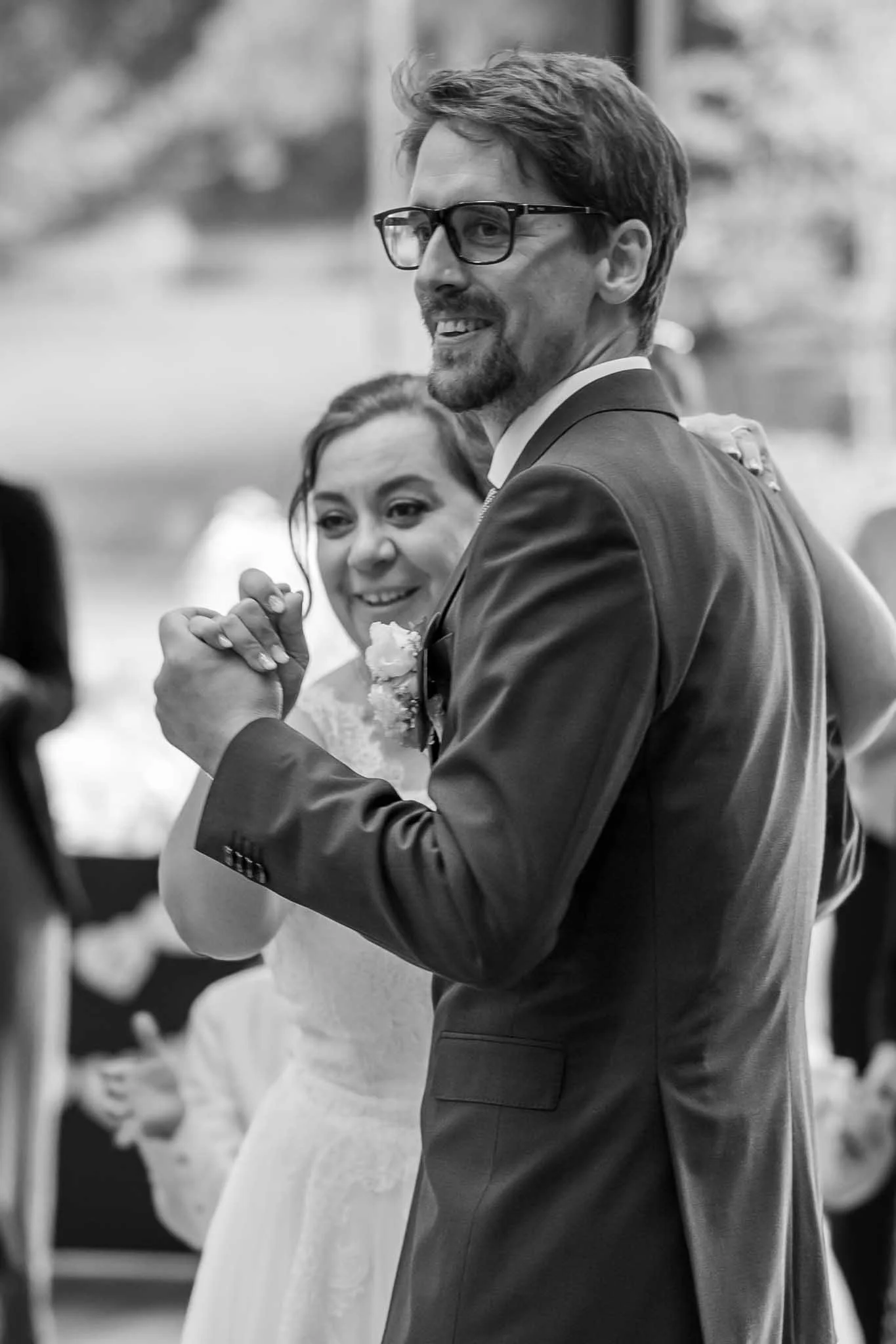 Schwarzweiß Bild von einem Brautpaar, welches in die Ferne blickt beim Tanzen