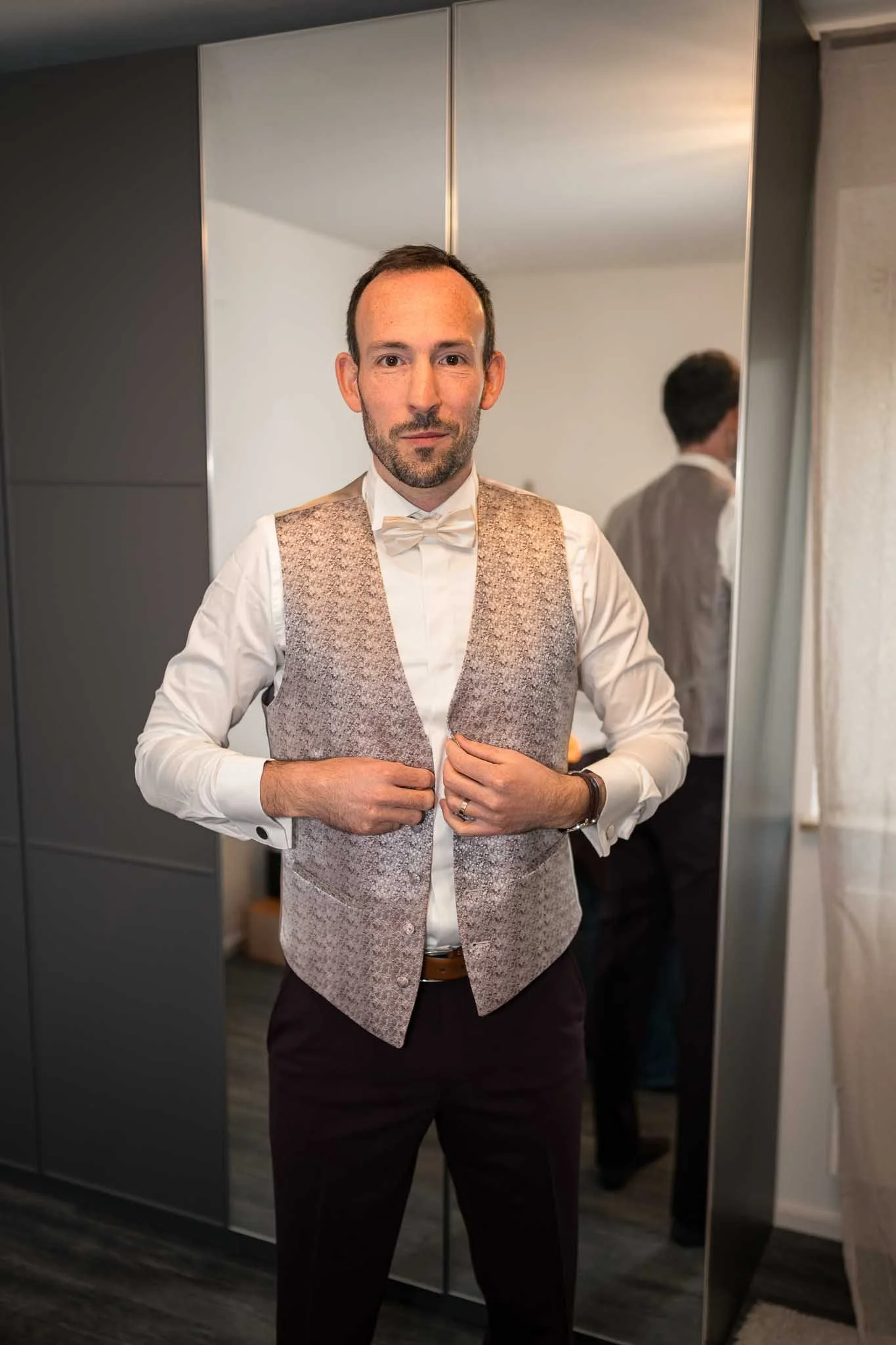 Halbkörper Aufnahme eines Mannes, der sich den Anzug zu knöpft