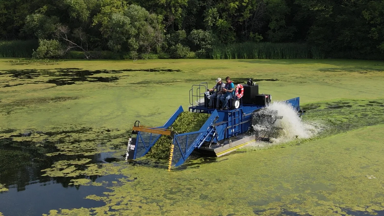Aquatic weed harvesting machine removing invasive lake vegetation for private property lake management in California