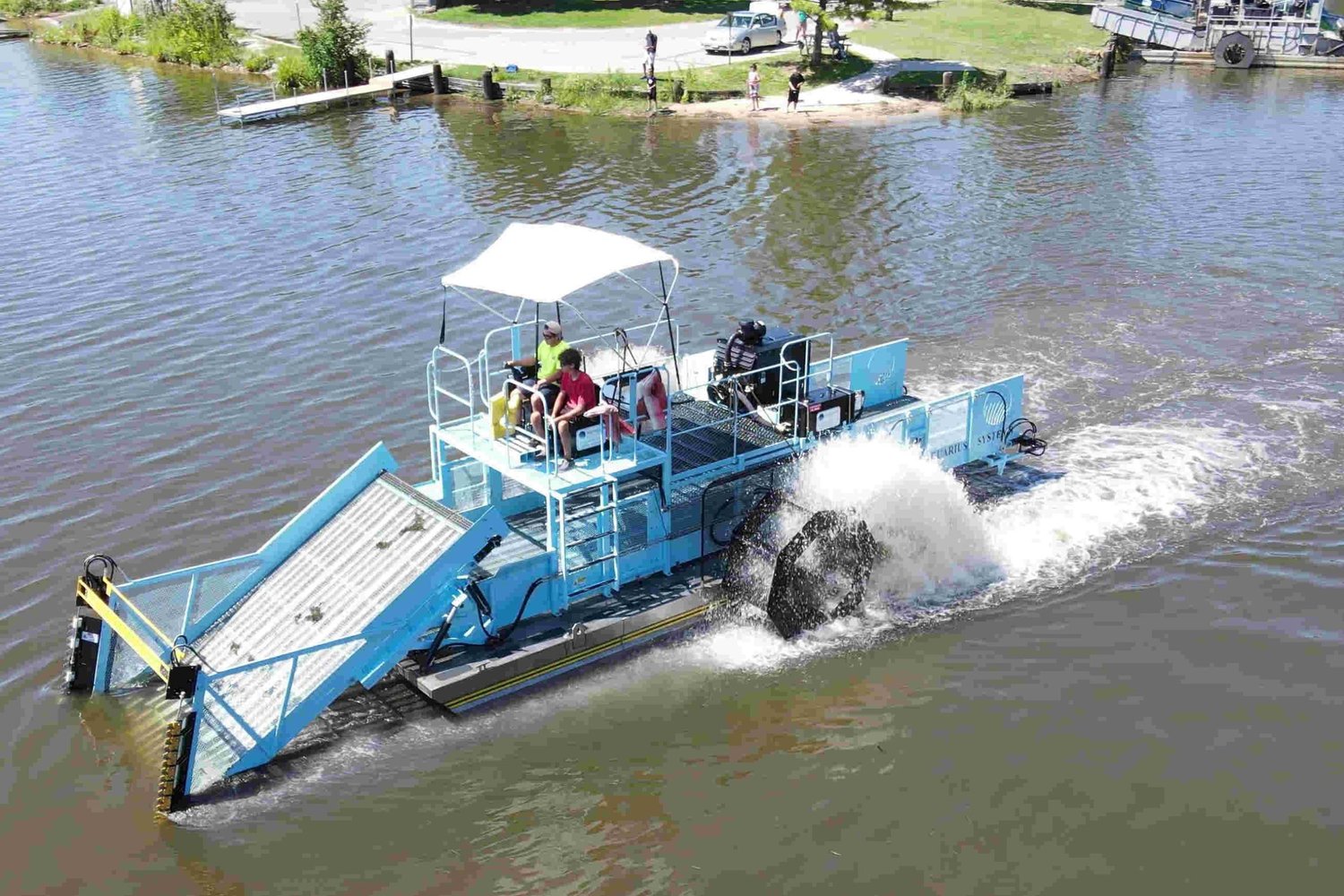 Aquatic weed harvester clearing invasive vegetation from HOA community lake for residential property management