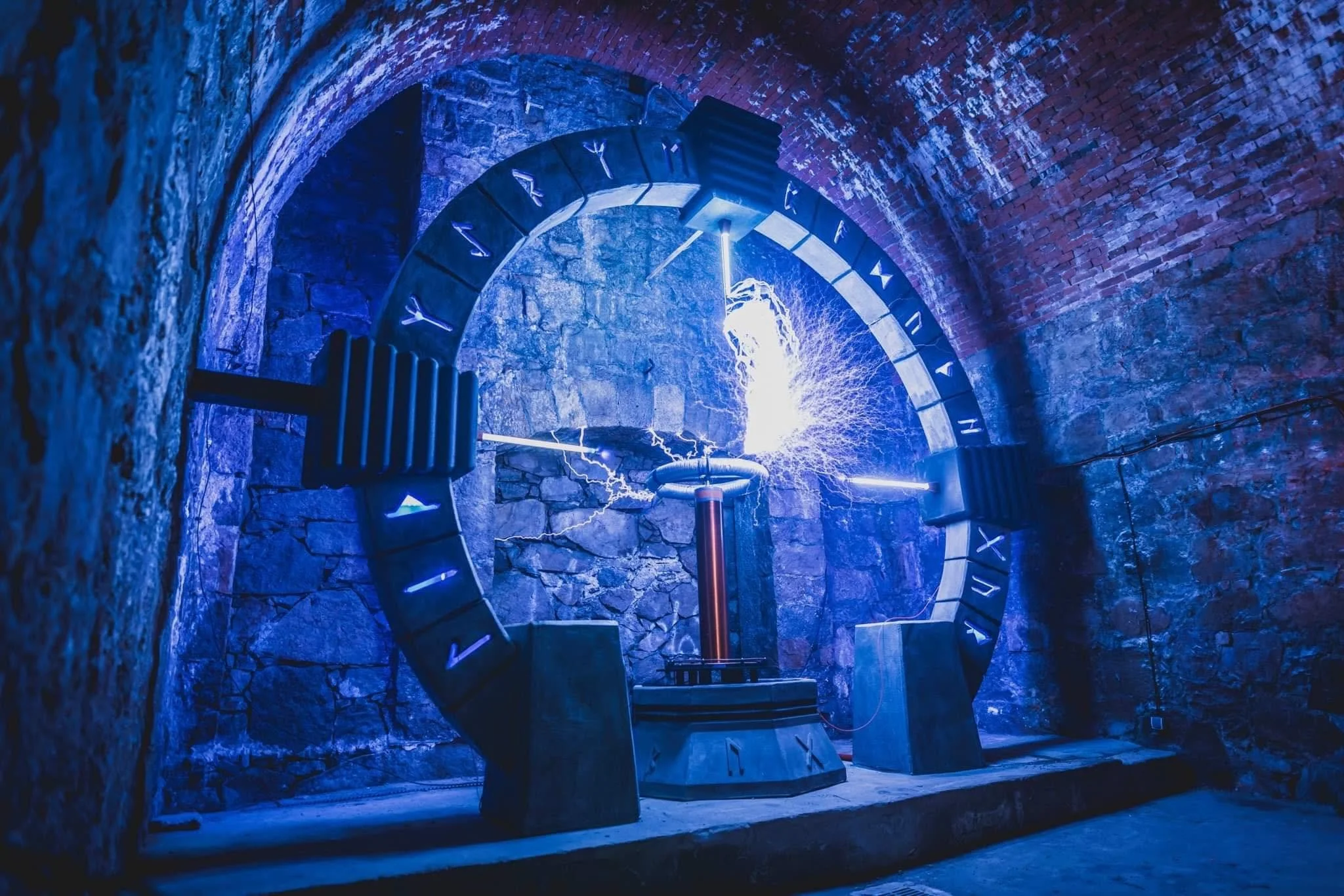 A large clock with Roman numerals and neon lighting inside a brick-walled tunnel, with a lightning bolt symbol at the center.
