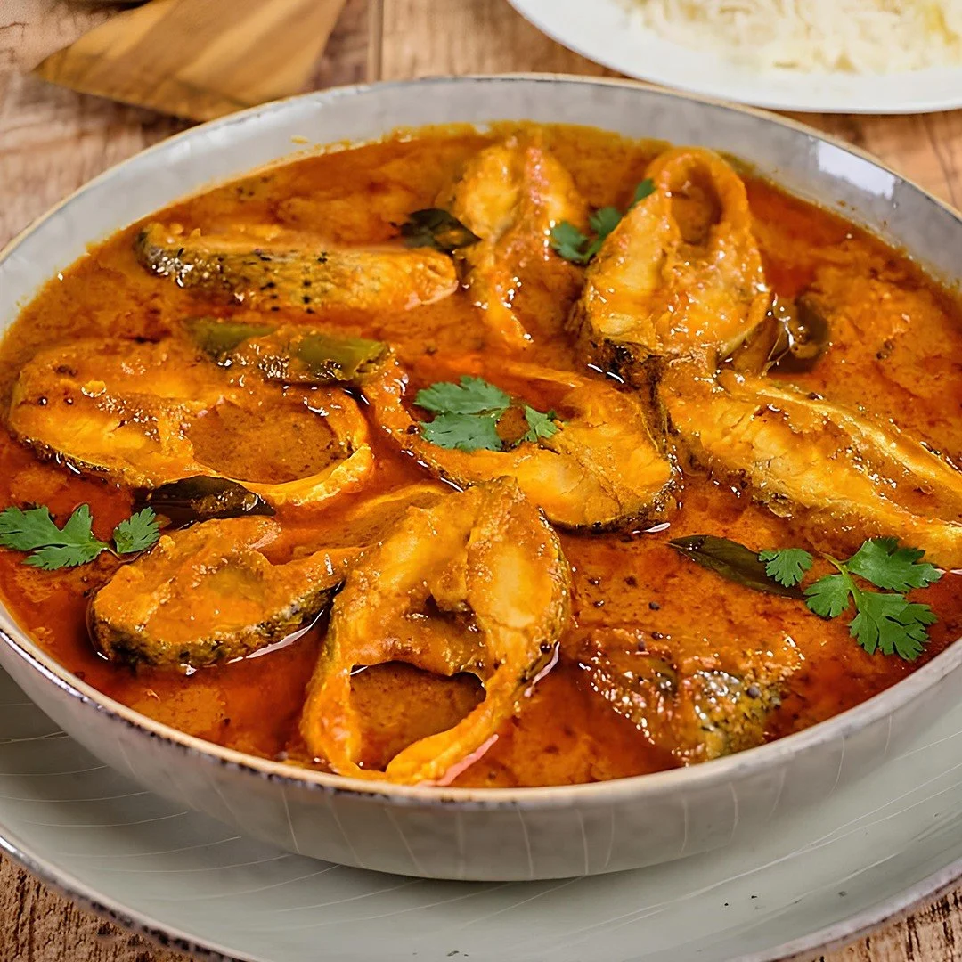 A bowl of fish curry garnished with cilantro.