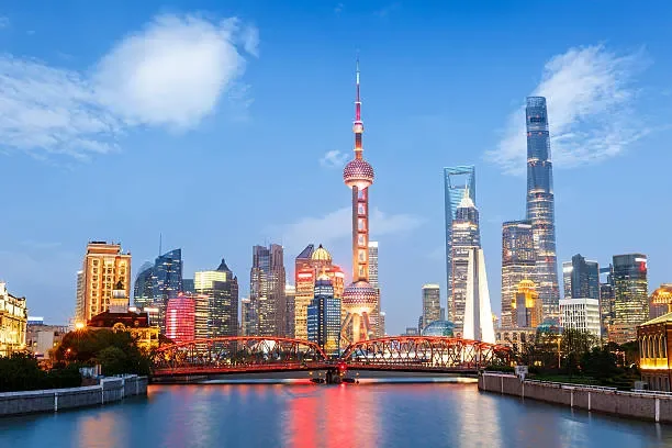 Shanghai skyline with tall skyscrapers and the Oriental Pearl Tower along the Huangpu River during the day.