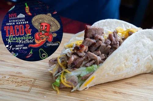 Close-up of a taco with shredded lettuce, shredded cheese, grilled meat, wrapped in a soft flour tortilla, on a wooden surface. Inset shows a colorful logo for the Syracuse Inner Harbor Taco & Margarita Festival, featuring a cartoon chili pepper wearing a sombrero, playing a guitar, with event details and neon-themed decorations.