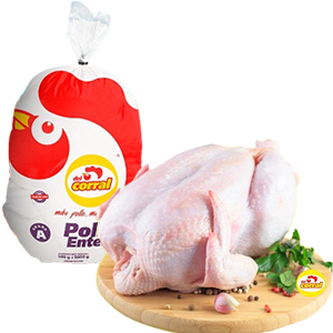 Raw whole chicken on a wooden cutting board with a pack of Corral Pollo Pollo, a plastic bag with a red and white label, and some herbs and garlic.
