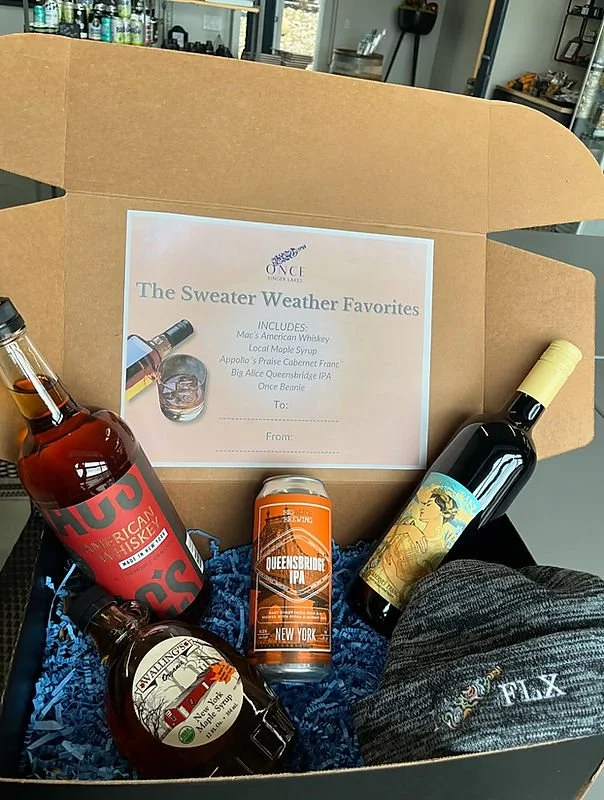 Gift box containing three bottles of wine, a can of Queensbridge IPA beer, and a card with the message "The Sweater Weather Favorites."