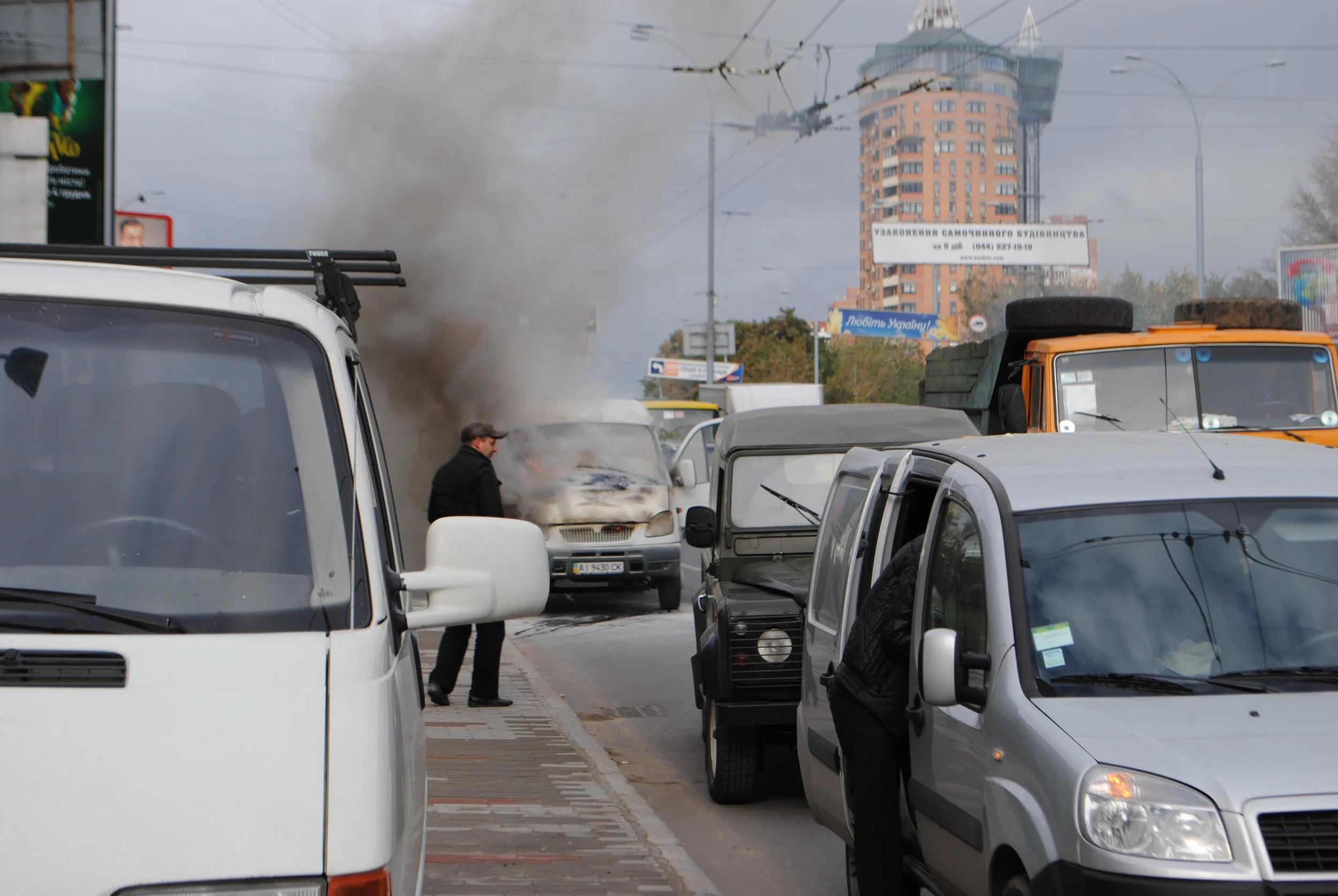 Traffic jam on the street with multiple parked cars and a building in the background. Kiev November 2011, Marina Parrish ©