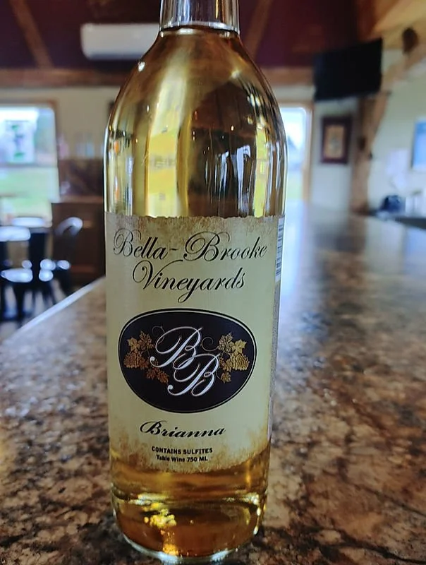 A bottle of white wine on a granite countertop inside a house.