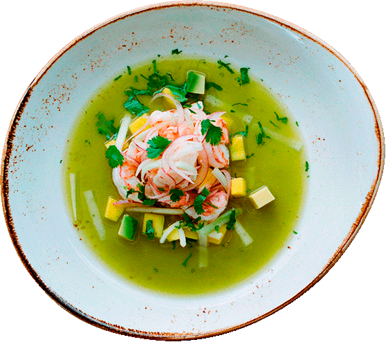Soup with green broth, garnished with shrimp, chopped green onions, cilantro, and small cubes of vegetables.