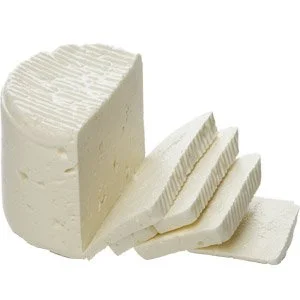 Sliced wheel of white cheese on a white background