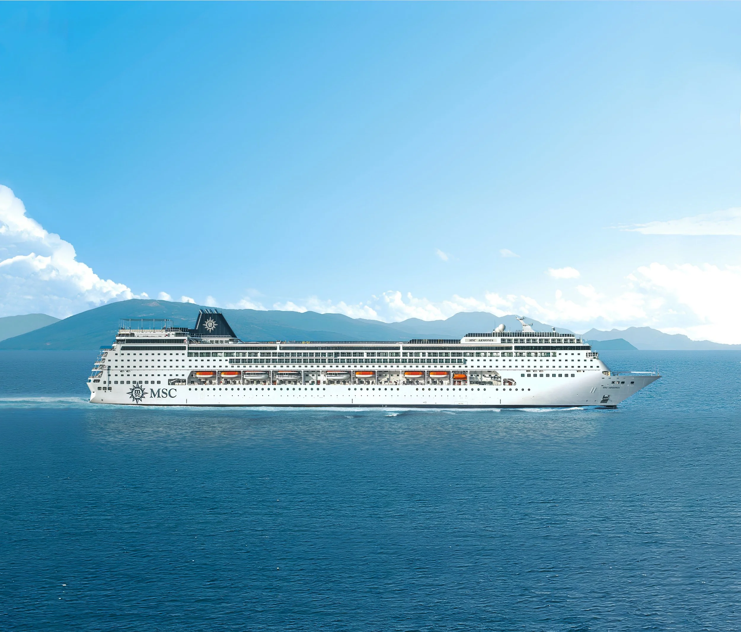 Large white cruise ship with multiple decks sailing on calm water under cloudy sky, named Costa Diadema.