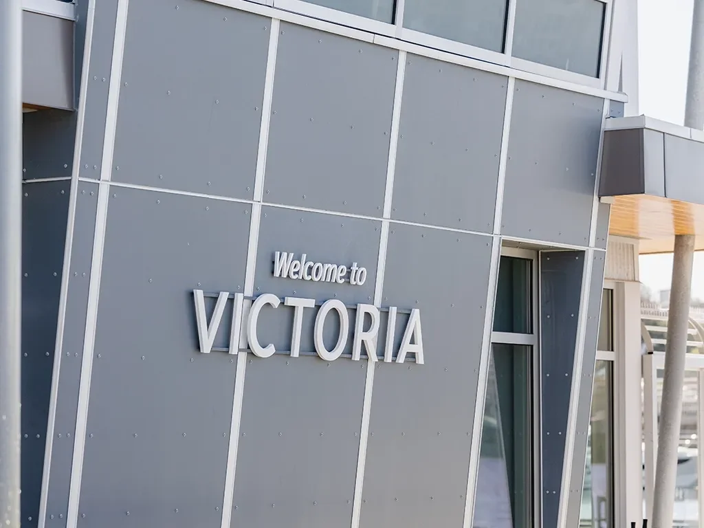 Close-up view of a modern building with a sign that reads 'Welcome to VICTORIA.'