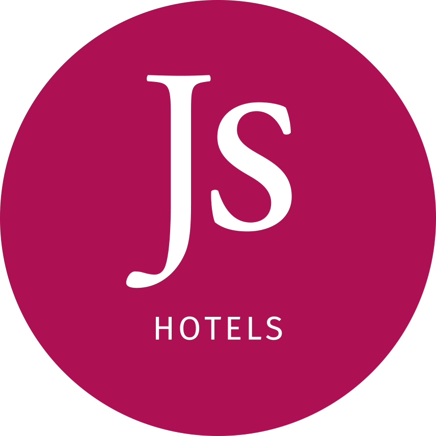 Logo for J's Hotels with a maroon circular background, the letter 'J's' in large white font, and the word 'HOTELS' underneath in smaller white font.