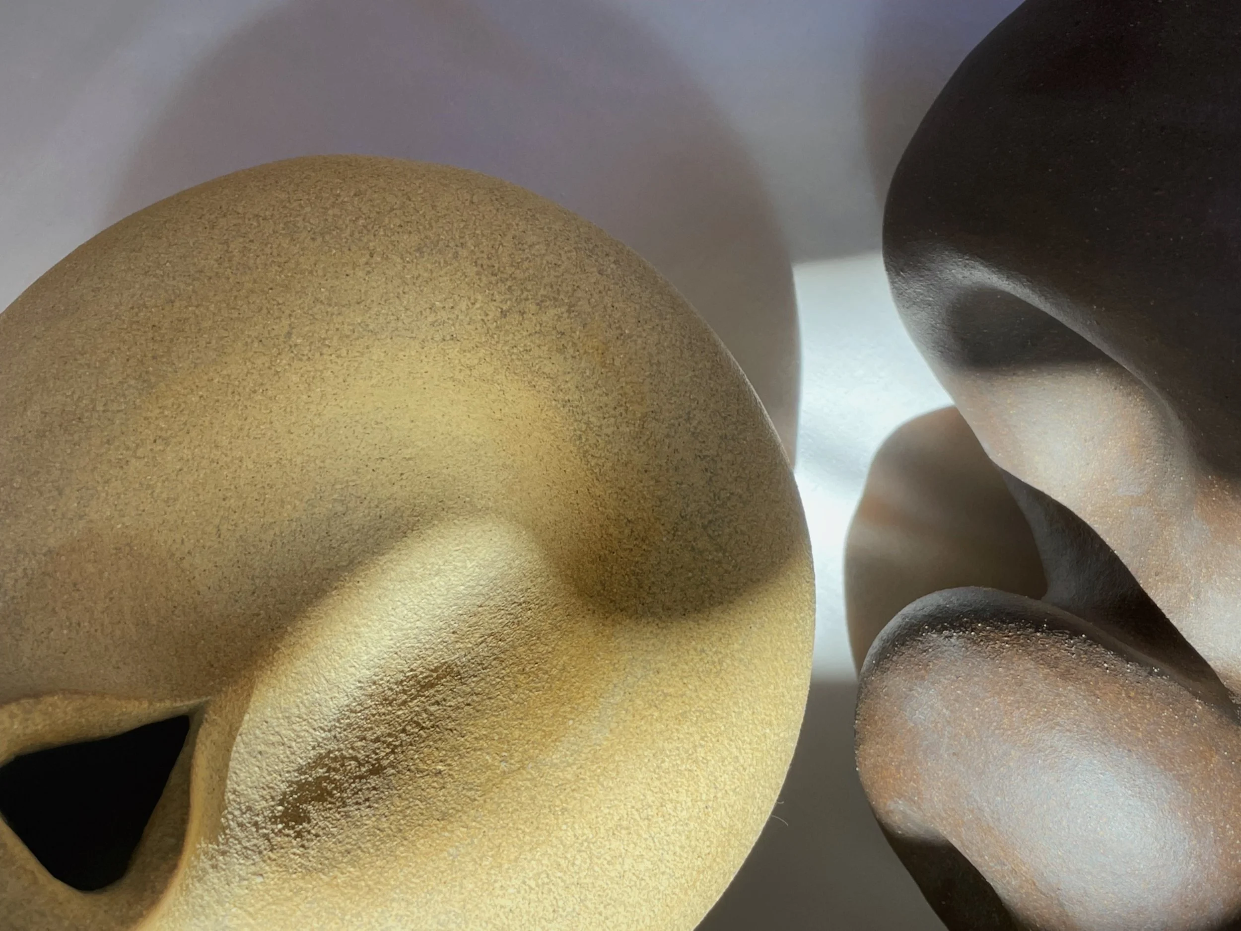 Light and dark clay sculpture that has light hitting it in a way that makes for an intimate and moody vibe.