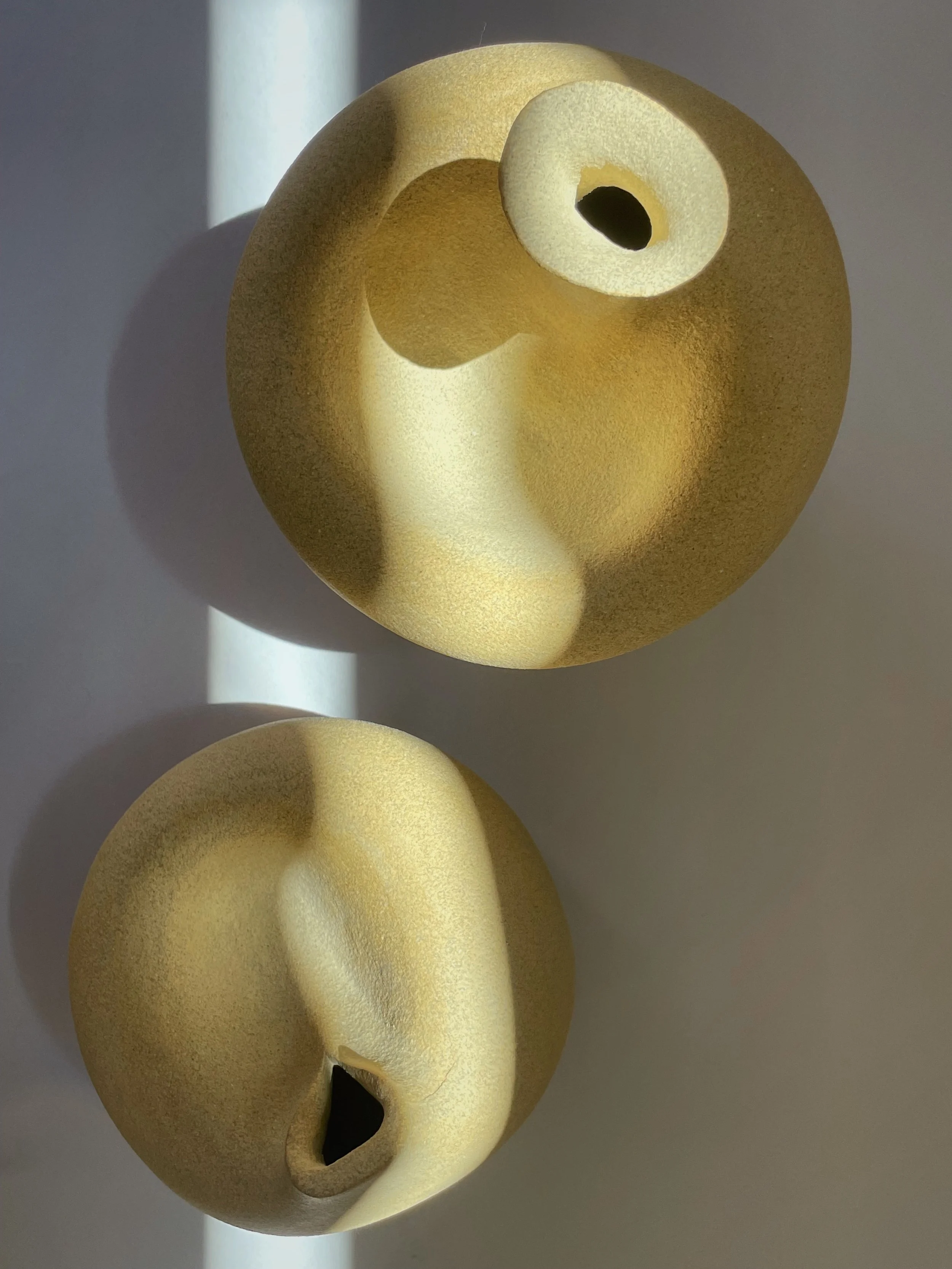 Light clay sculpture with a skylight hitting it that forms a romantic and moody atmosphere.