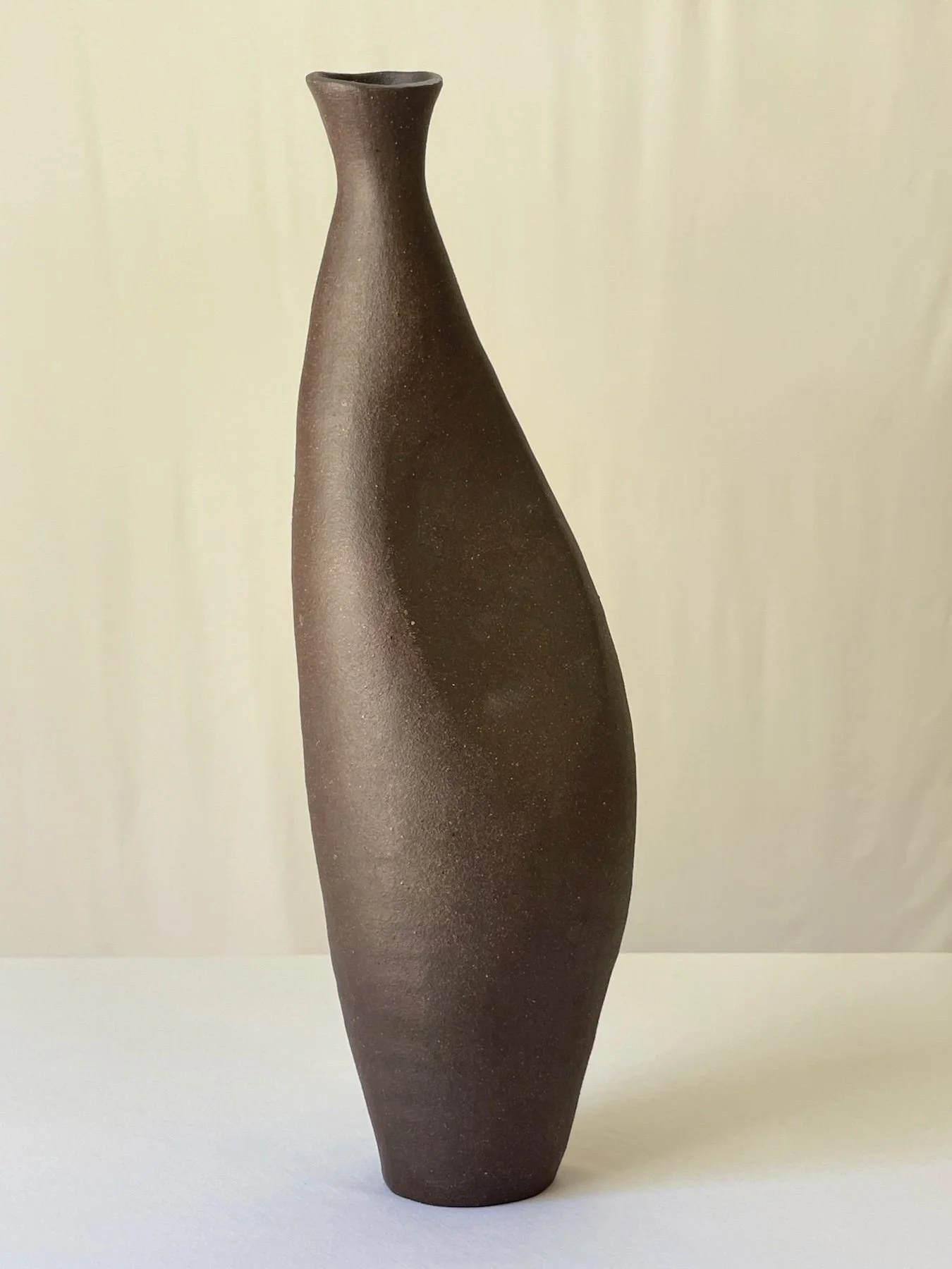 dark clay sculpture with a flat side or dent