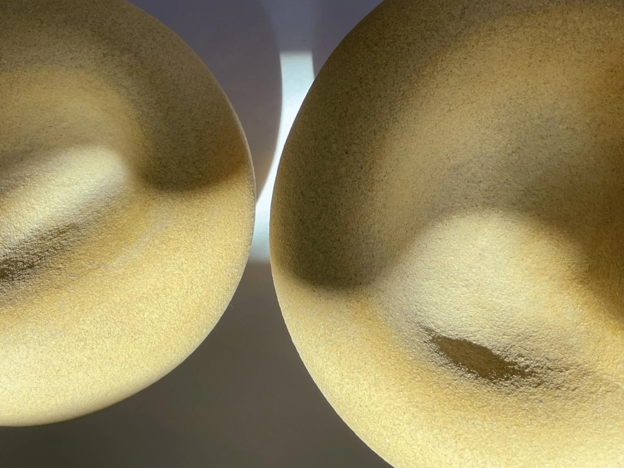 Light clay sculptures that have sunlight on it that reflects the shape of ying and yang.