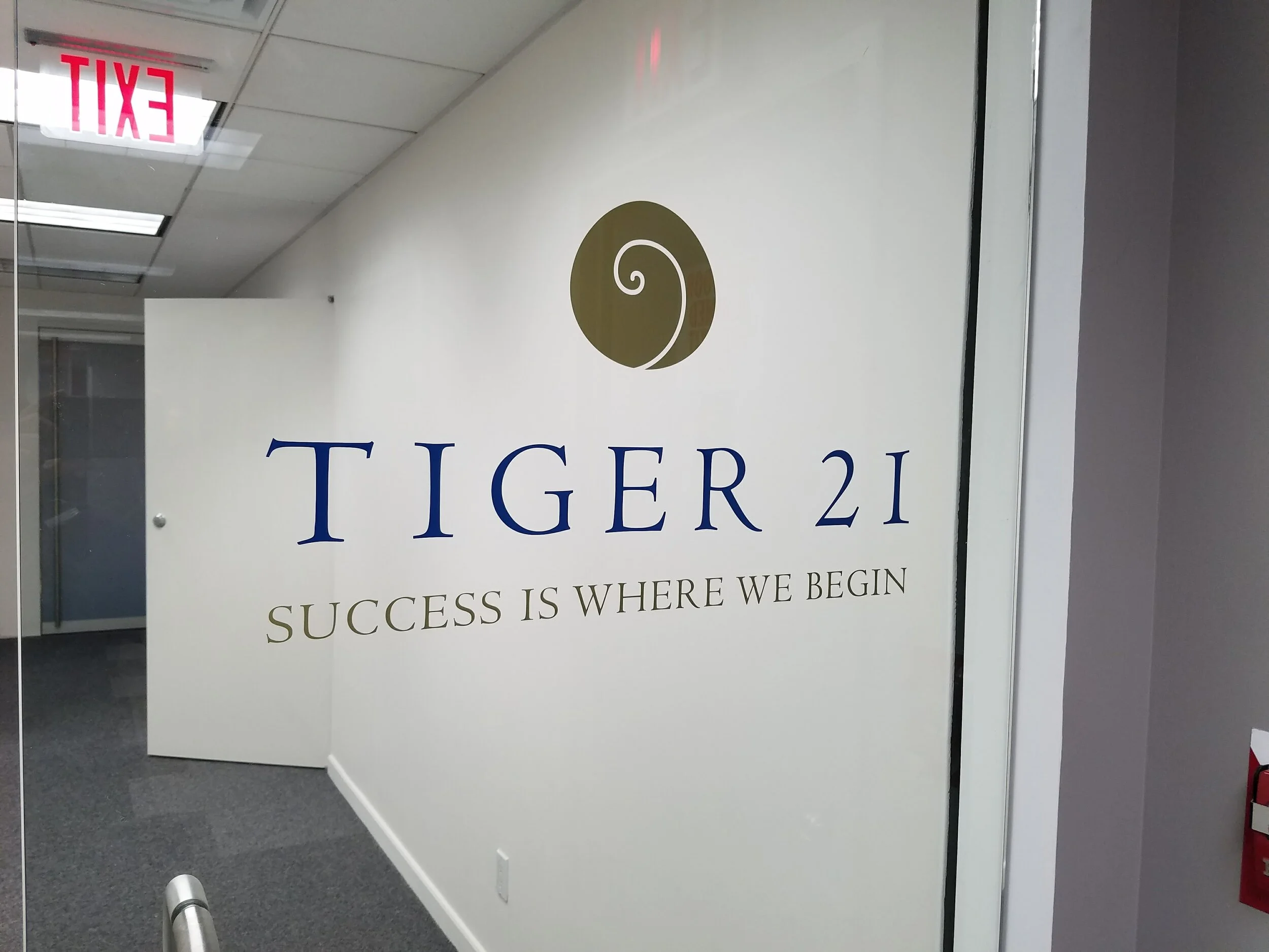 Custom cad-cut adhesive vinyl logo graphics applied to clear glass door inside commercial office space in New York, NY.