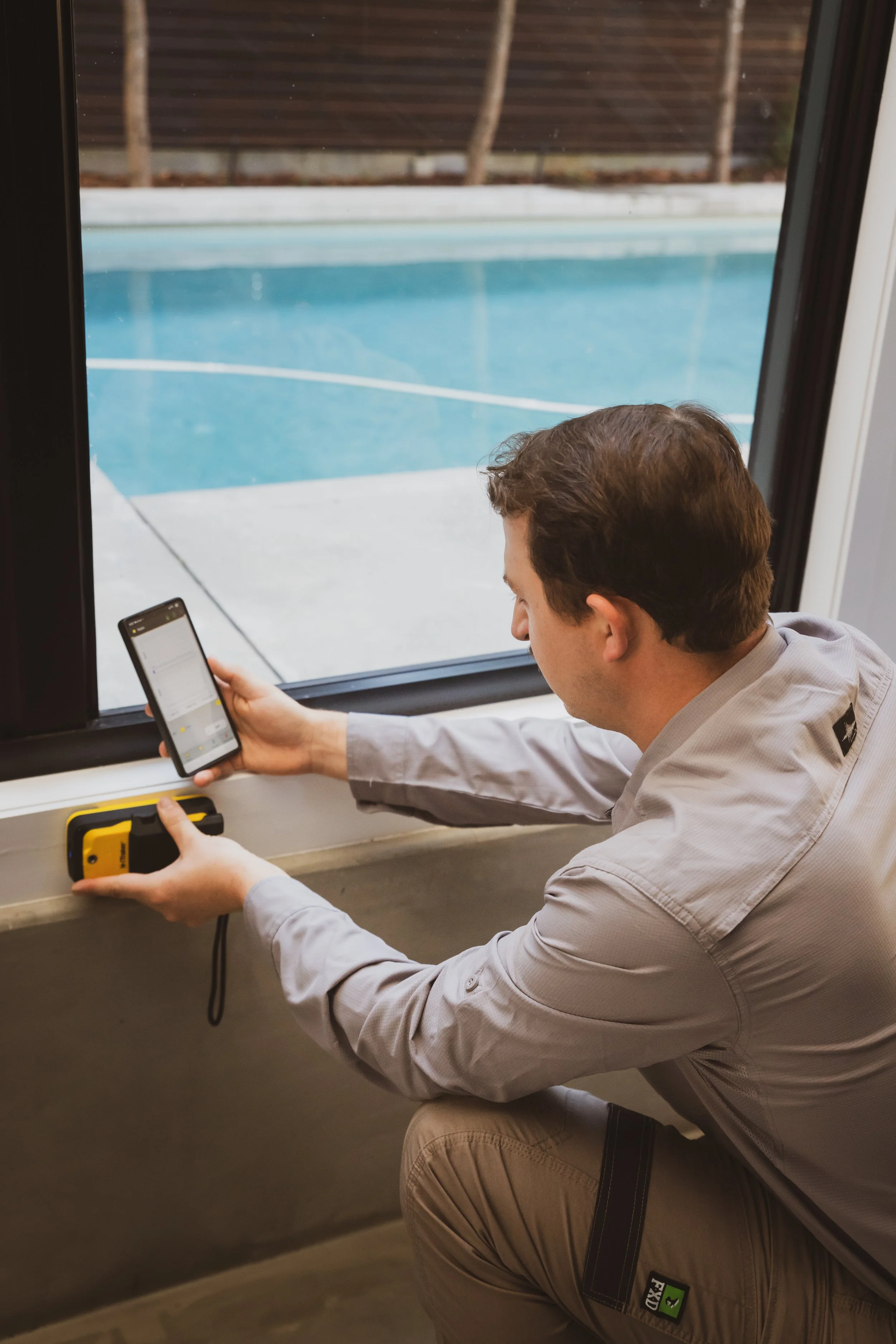 A technician using a Termatrac device during a termite inspection to detect hidden termite movement inside the timber.