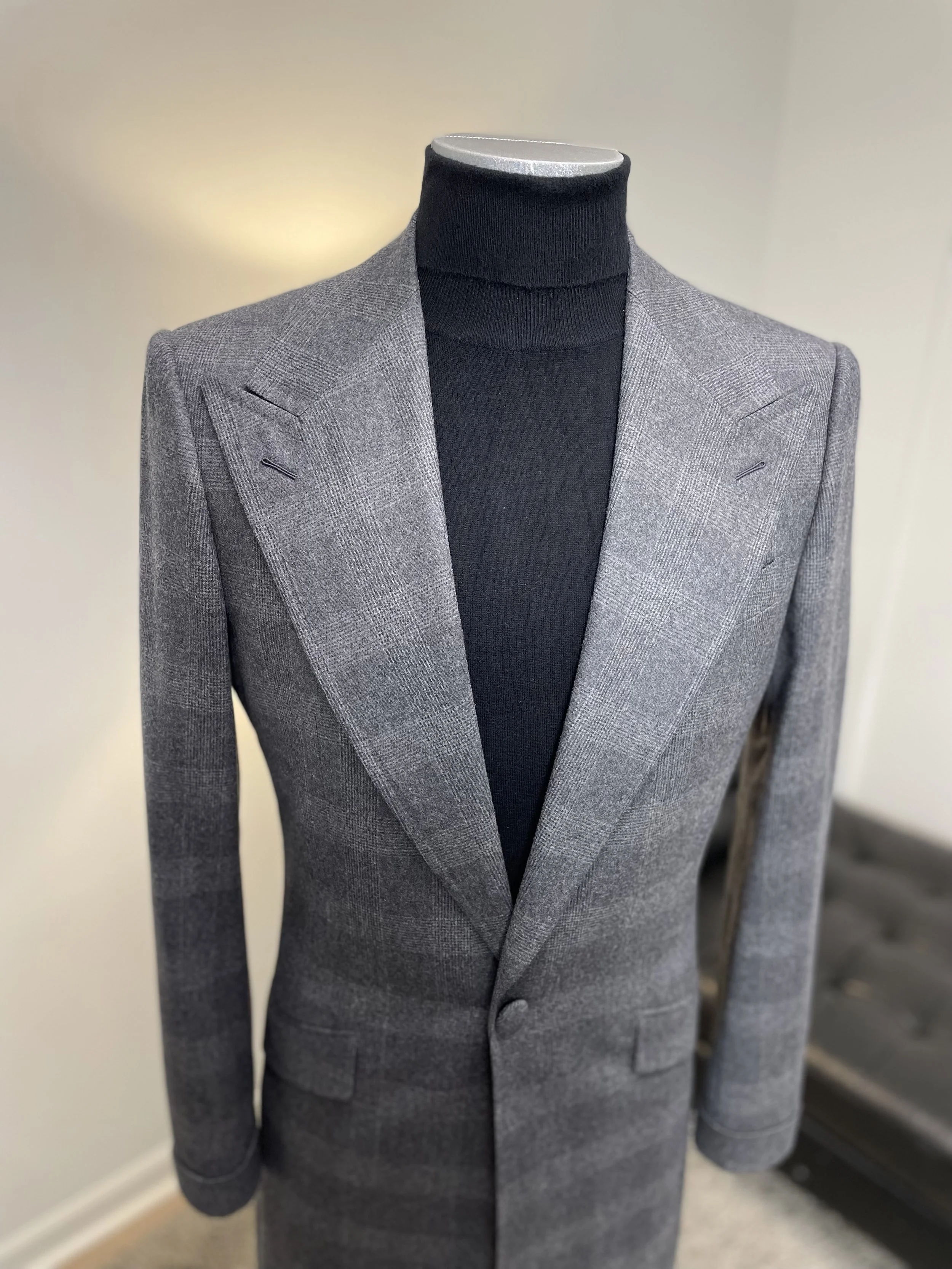 Gray suit jacket on a mannequin with black turtleneck underneath.