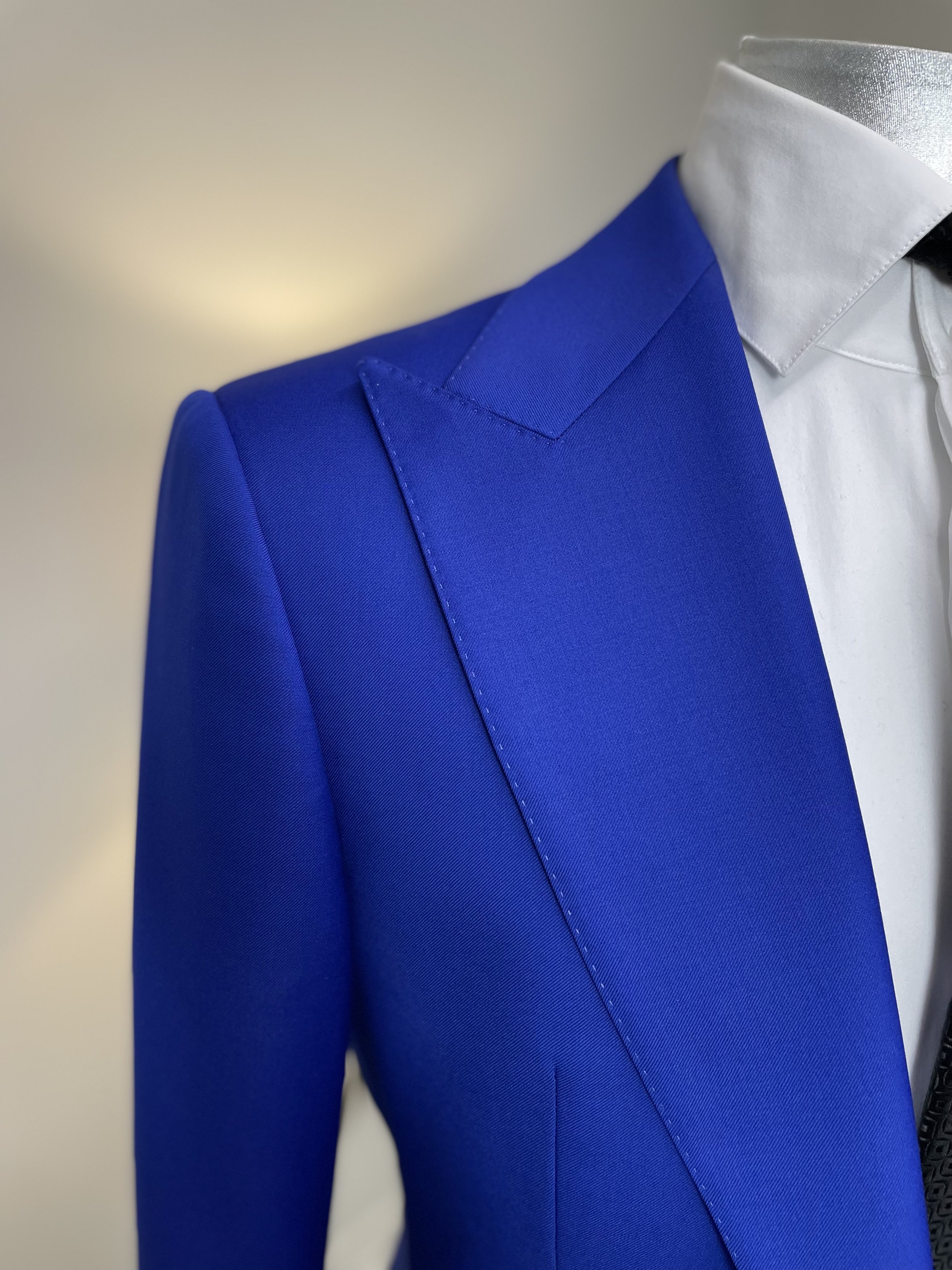 Close-up of a mannequin wearing a white dress shirt with a silver jacket and a bright blue blazer.