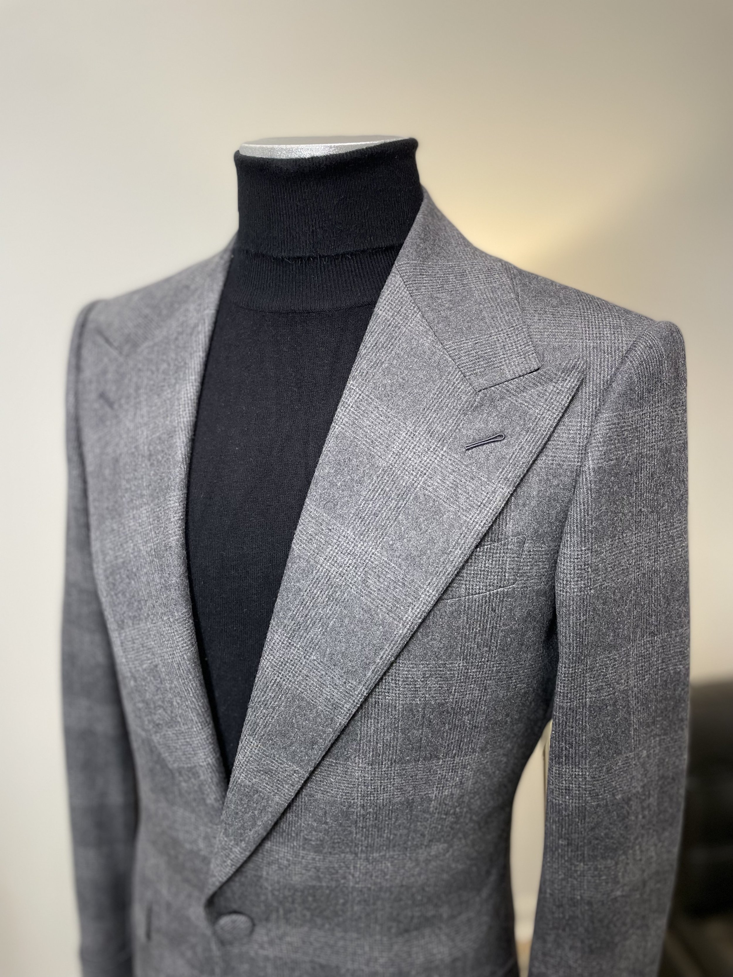 Gray checked blazer jacket with black turtleneck on a mannequin
